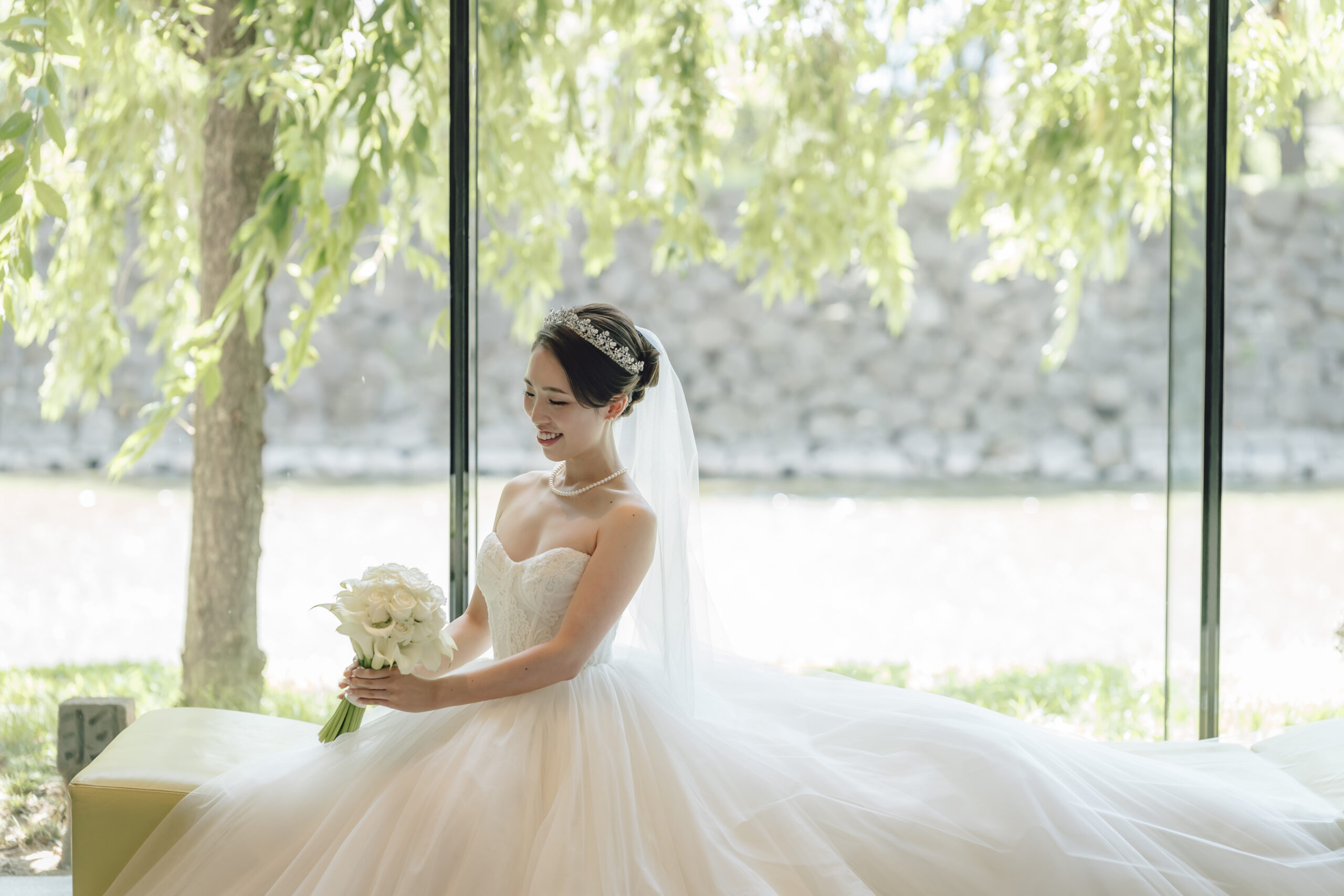 ザトリートドレッシングのみでお取り扱いのあるモニークルイリエのプリンセスラインのチュールドレスに合わせてホワイトのブーケとマリアエレナのティアラでクラシカルでありながらも透明感を引き立てるコーディネートが完成いたします