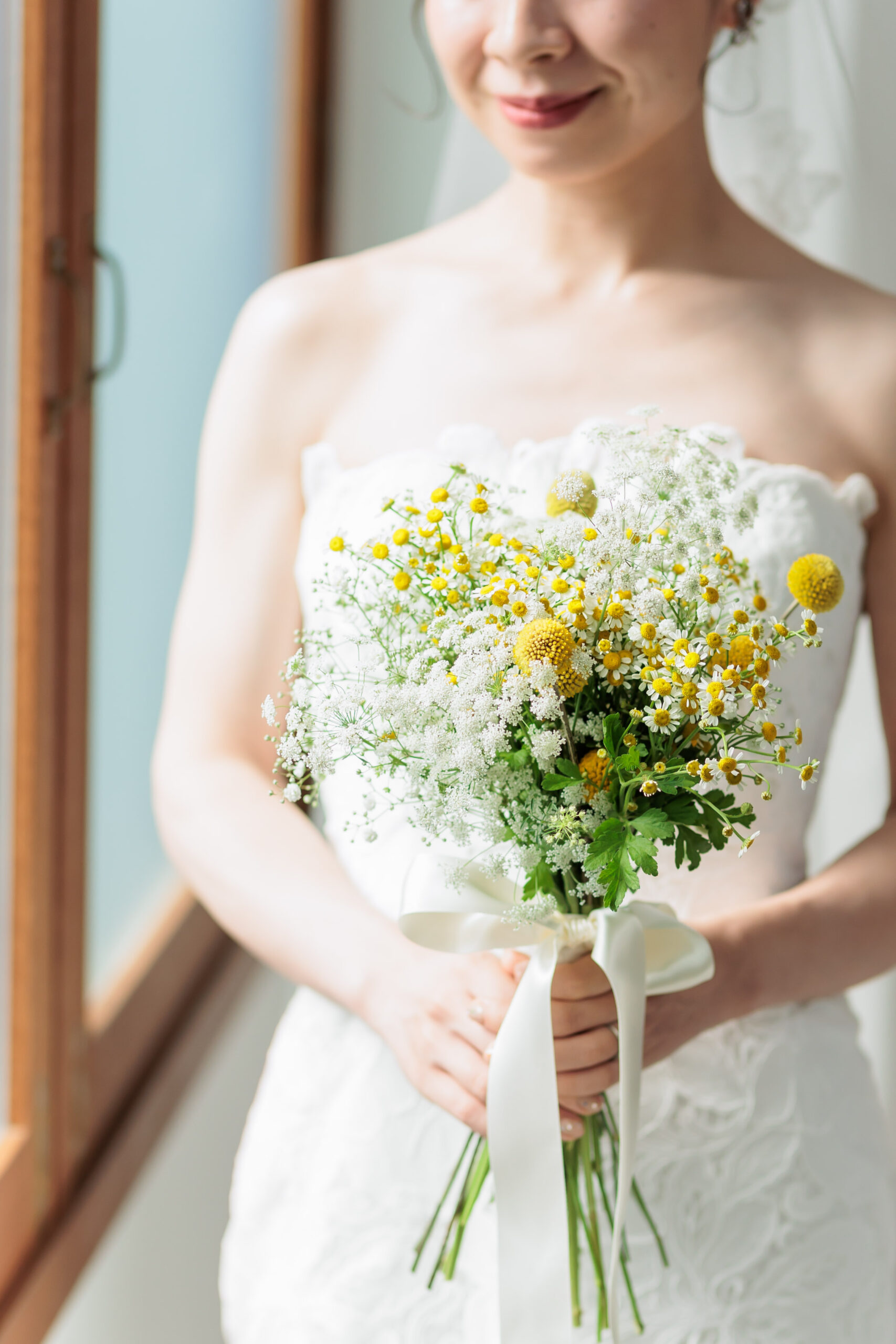 THE TREAT DRESSINGがおすすめしたい、レラローズのマーメイドラインのウェディングドレスと合わせたお二人らしいあたたかな結婚式に人気のイエローブーケのコーディネート