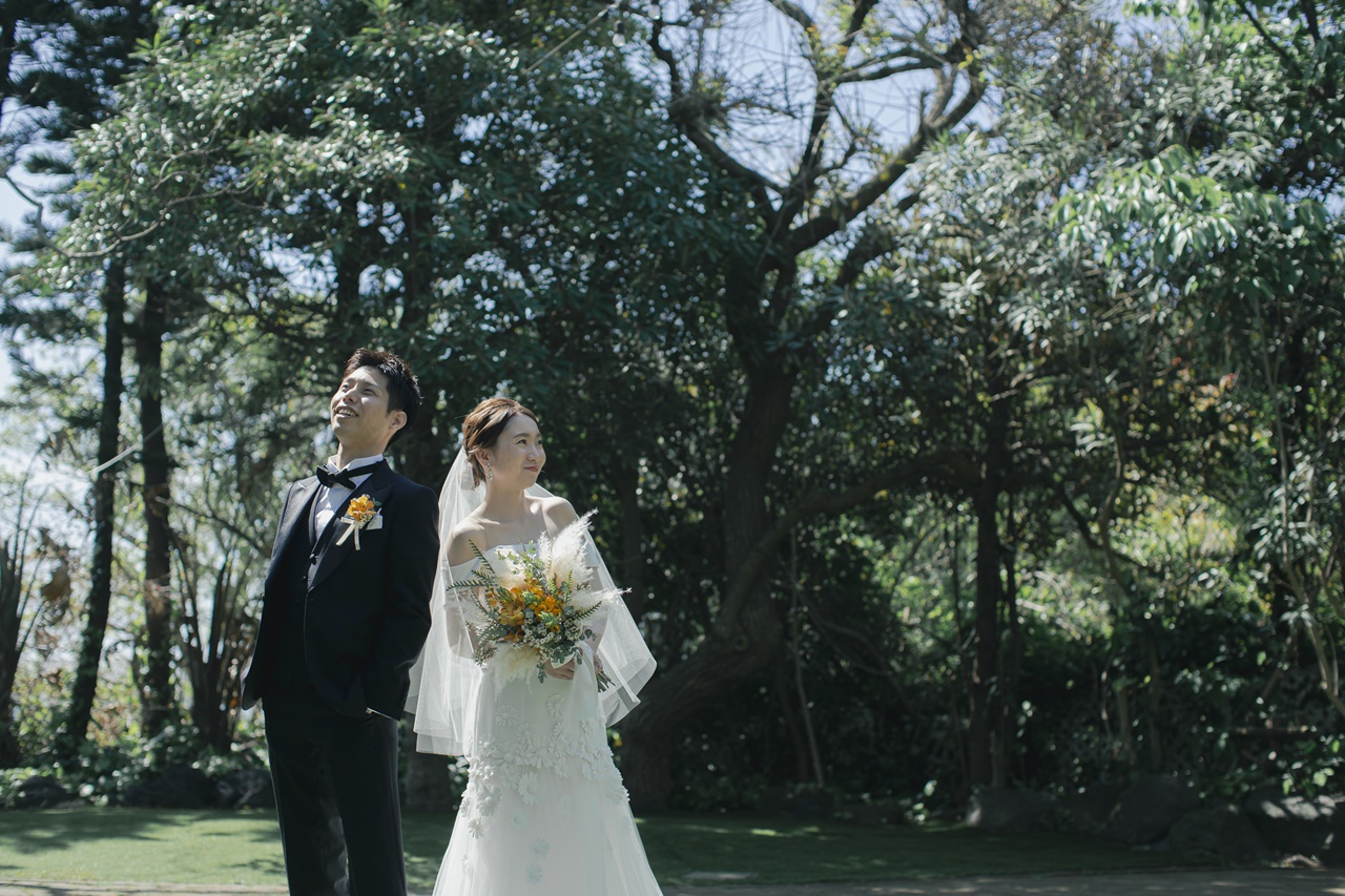 ヴィクター アンド ロルフ マリアージュのウェディングドレスとブラックのタキシードが自然あふれる会場にぴったりです