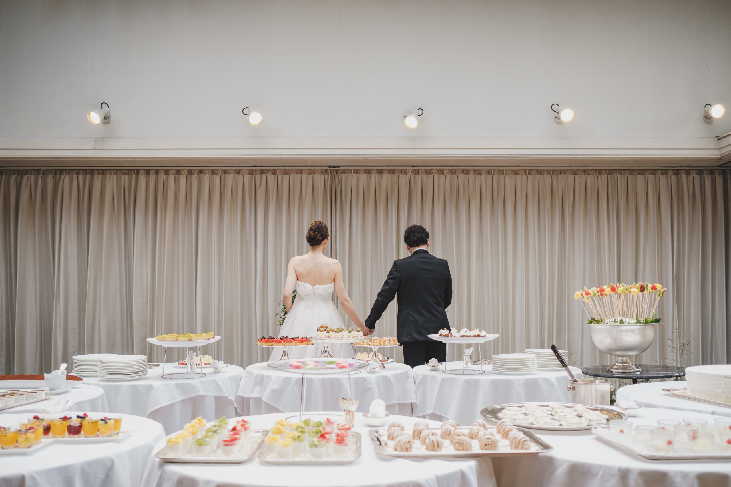 リストランテASOで人気のデザートブッフェのスタートとともに入場されるモニークルイリエのウェディングドレスに身を包んだ花嫁様とブラックタキシードを着こなすご新郎様