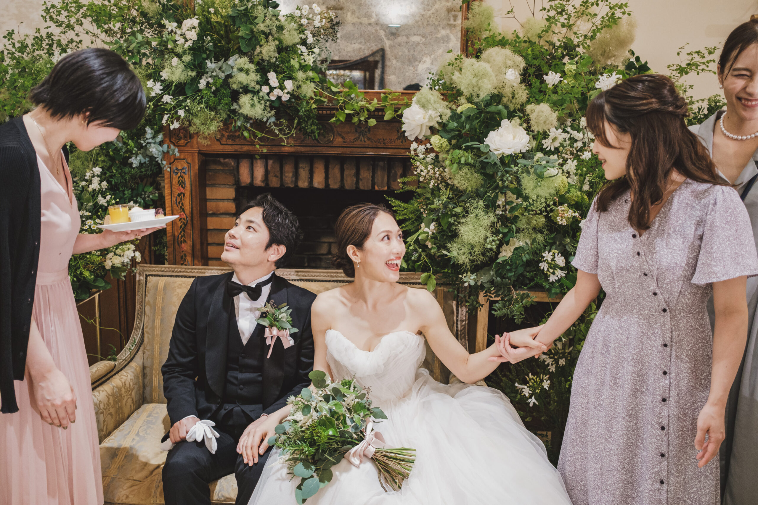 柔らかなブラッシュカラーのチュールをふんだんに使用したモニークルイリエのプリンセスラインのウェディングドレスをお色直しで纏うご新婦様とトリートジェントルマンのブラックのタキシードに身を包むご新郎様