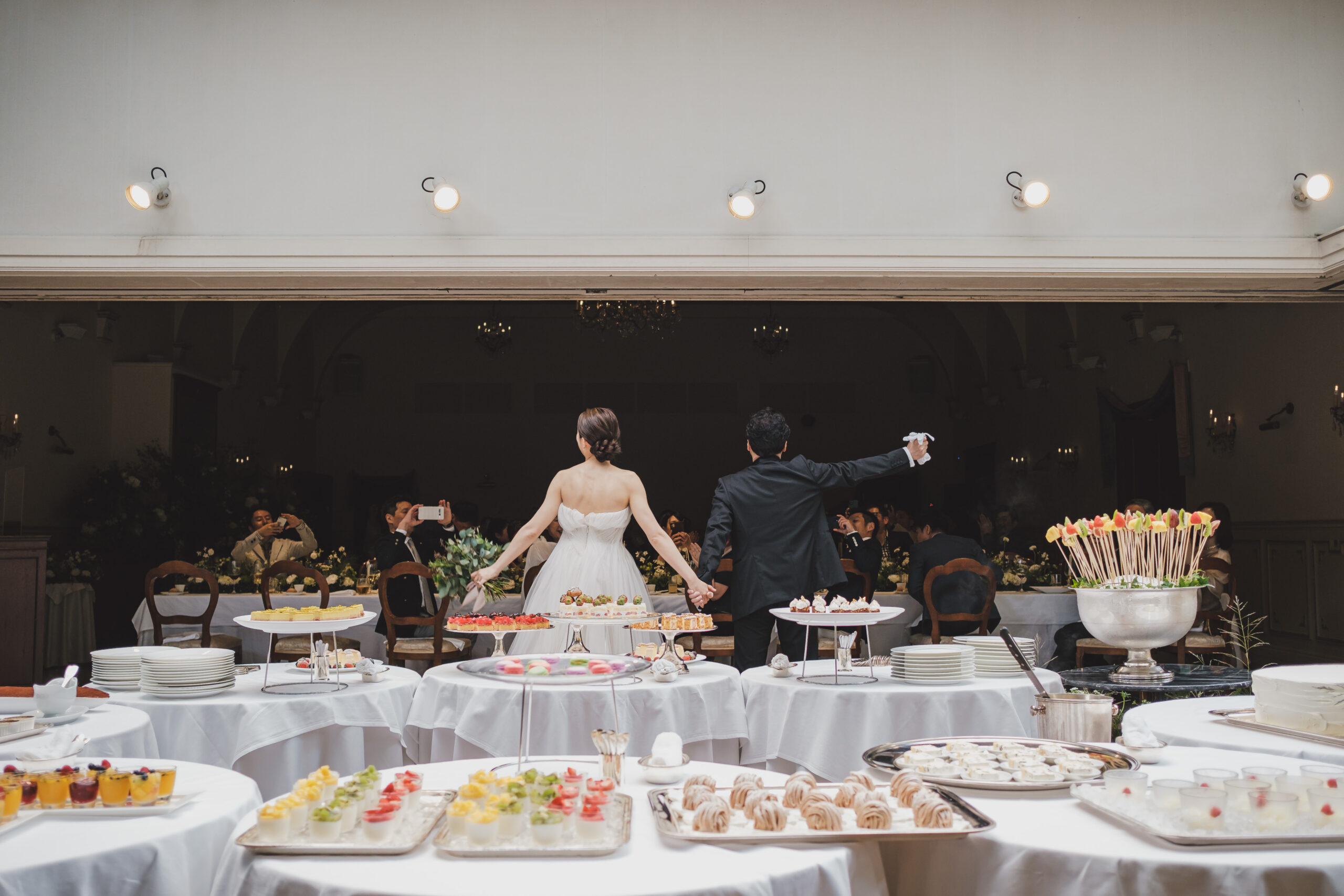 リストランテASOで人気のデザートブッフェのスタートとともに入場されるモニークルイリエのウェディングドレスに身を包んだ花嫁様とブラックタキシードを着こなすご新郎様