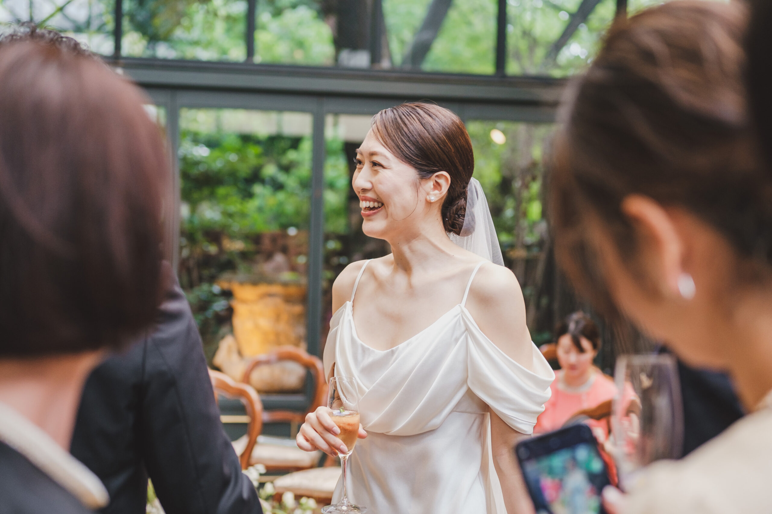 ザトリートドレッシングでお取り扱いのあるシンプルで上質なエリザベスフィルモアのウェディングドレスを纏い、多くのゲストの皆様の笑顔に囲まれる花嫁様