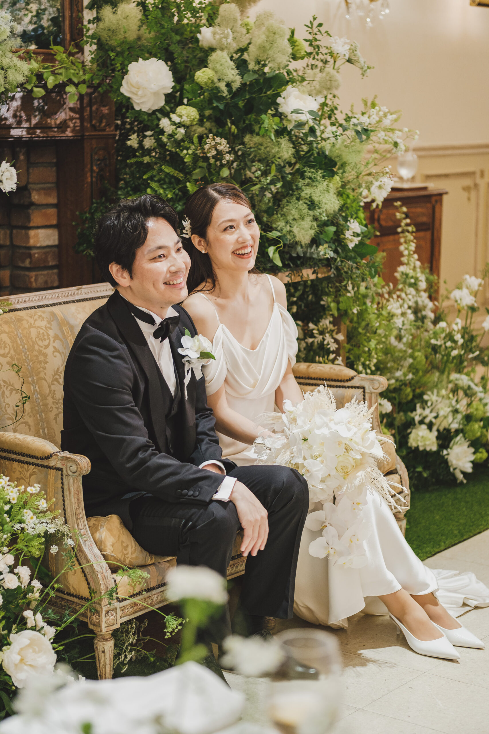 ブラックのタキシード姿のご新郎様とシンプルで洗練されたウェディングドレスをご新婦様