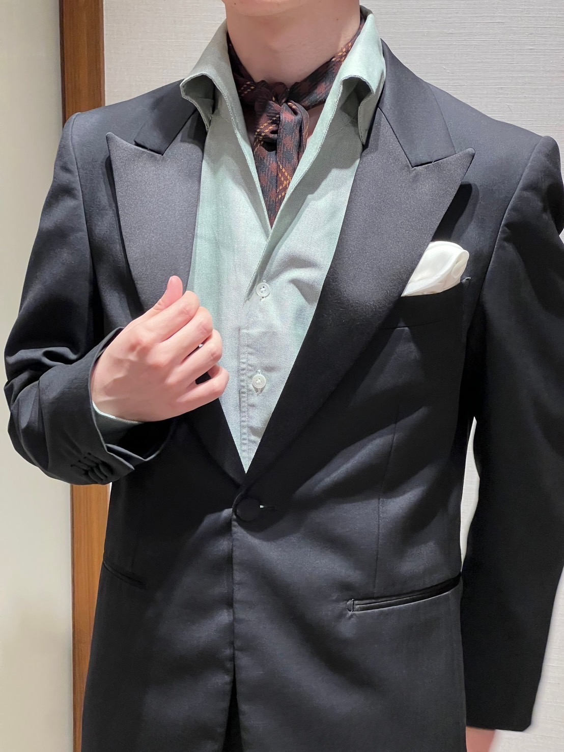 ブラックのタキシードにイタリアンカラーシャツとストールを合わせたスタイル