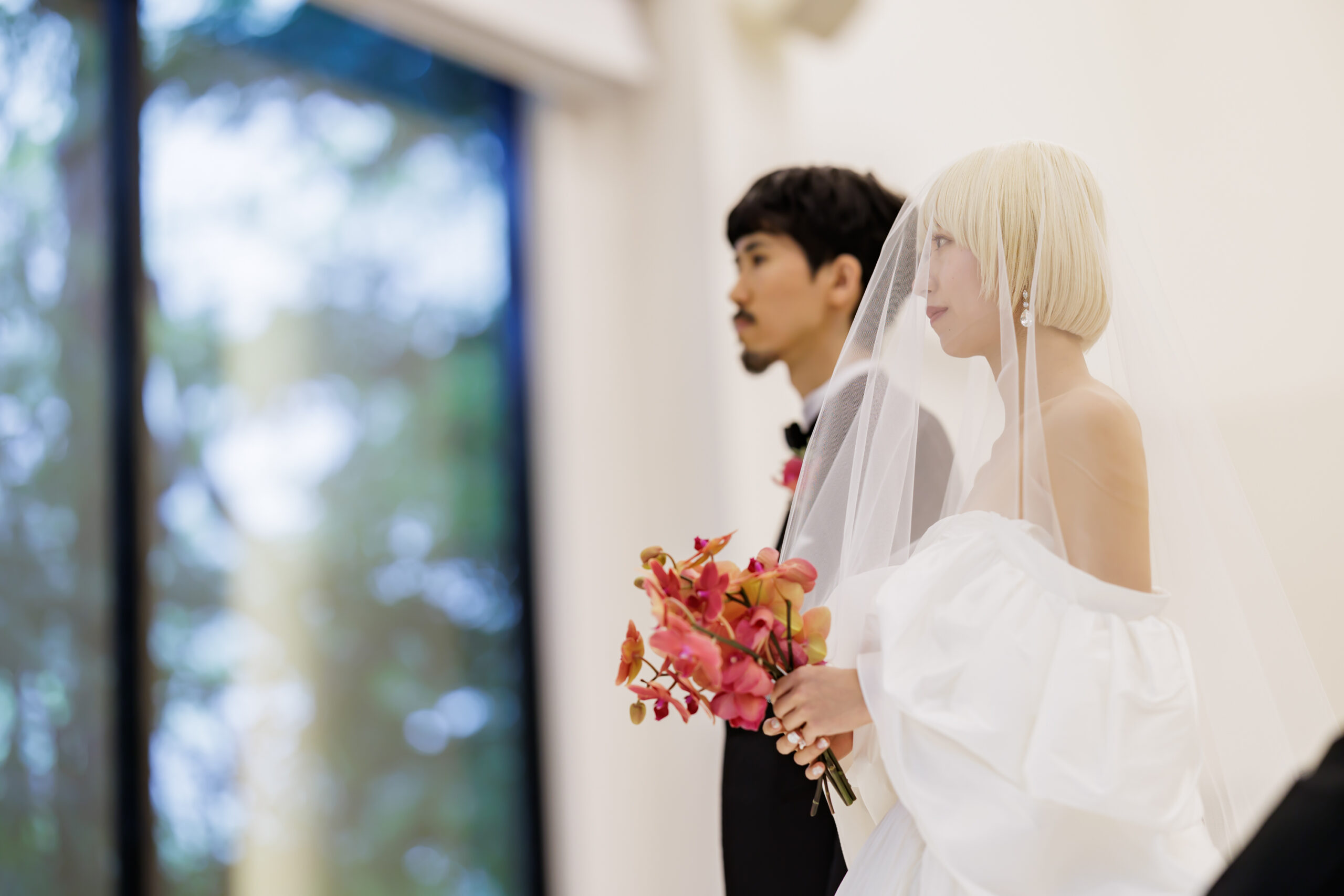 八芳園のチャペルでは自然光がたっぷりと差し込みアムサーラのウェディングを纏うご新婦様とトリートオリジナルのタキシードを纏うご新郎様を輝かせます