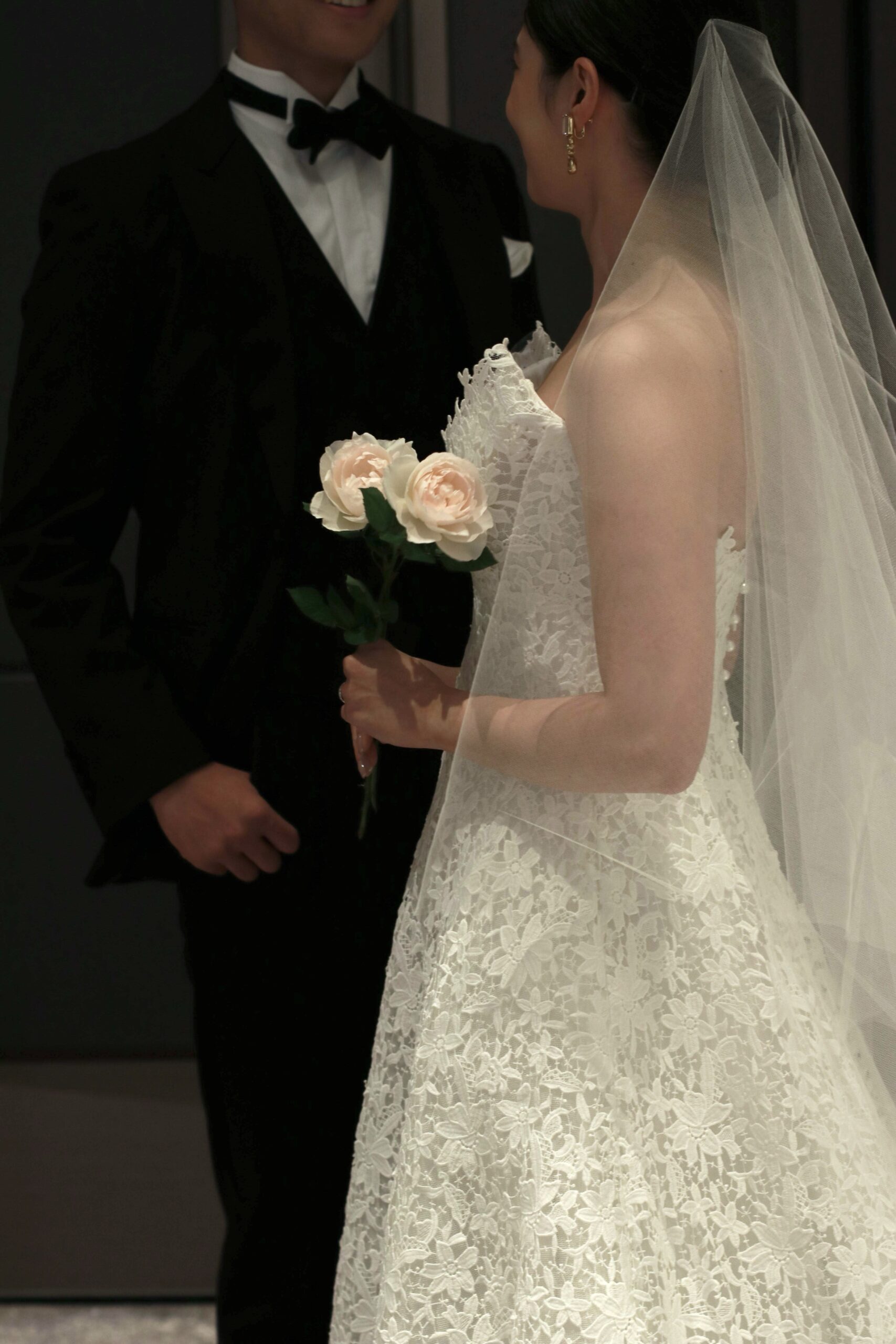 王道な結婚式を叶えるトリートのブラックのタキシードとモニークルイリエの総レース・Aラインのウェディングドレスを身に纏った新郎新婦