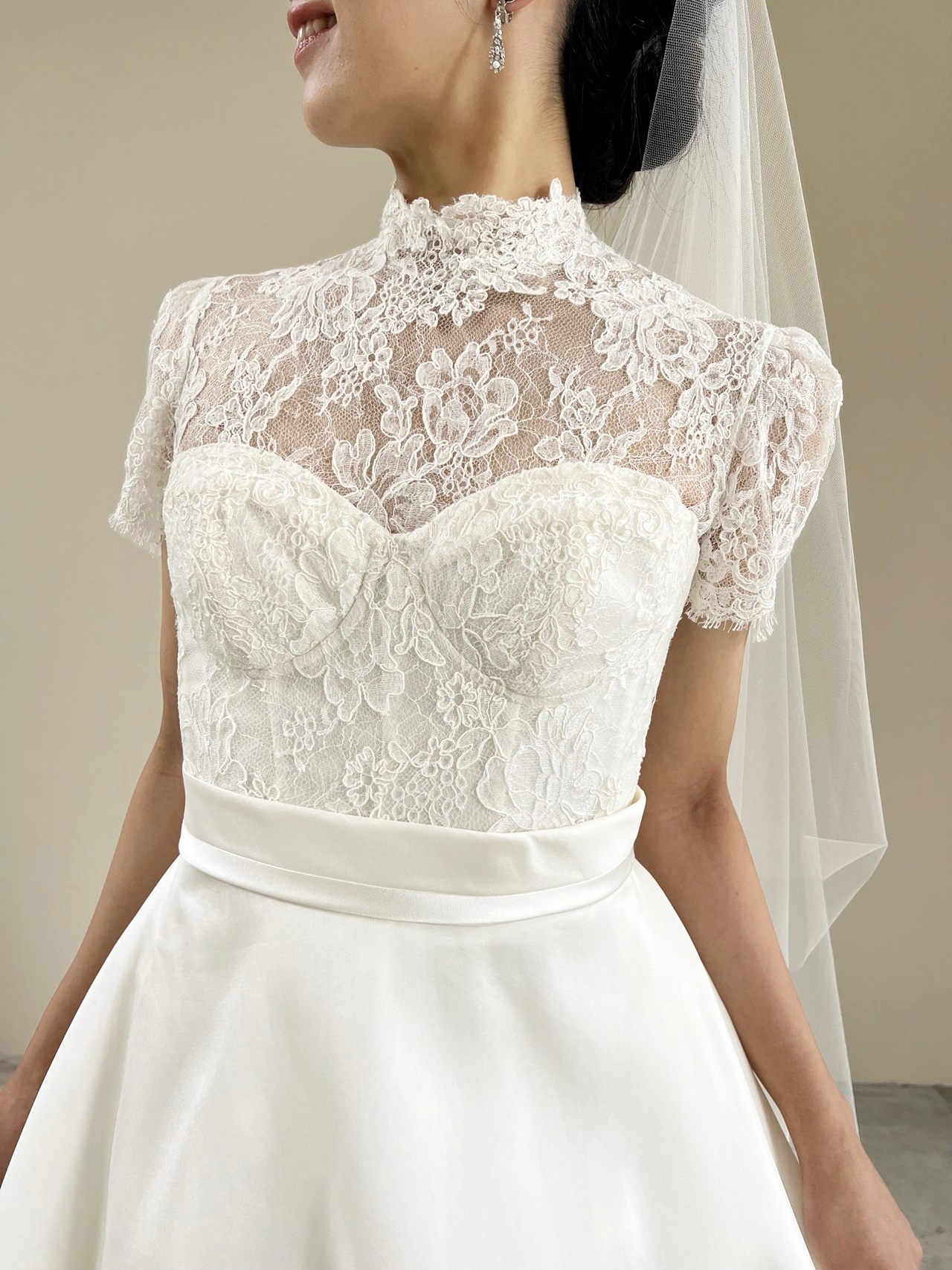 ハイネックの総レースが華やかなマーク イングラム フォー ヴァレンティーニのレンタルウェディングドレスは、女性らしくクラシカルなスタイルを叶えてくれます