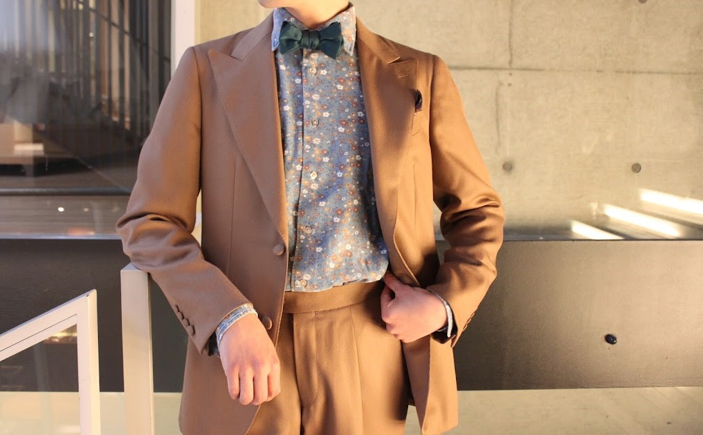 柔らかなべージュのウェアにボリエッロの柄シャツを合わせたカジュアルモダンな装い