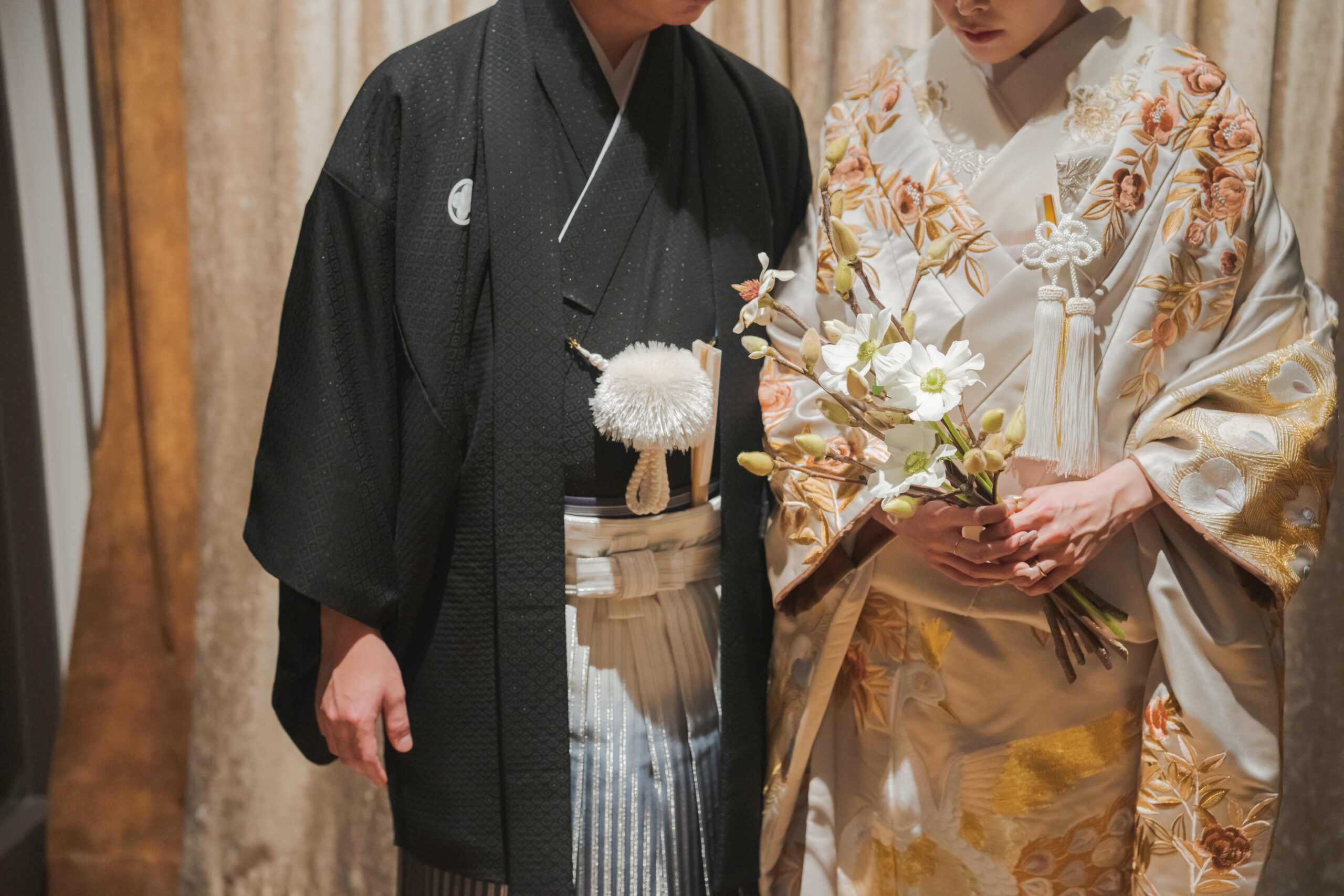 淡く上品な花と孔雀が描かれたトリート オリジナルの色打掛と、華やかで古典的な刺し子織りの黒の紋付袴