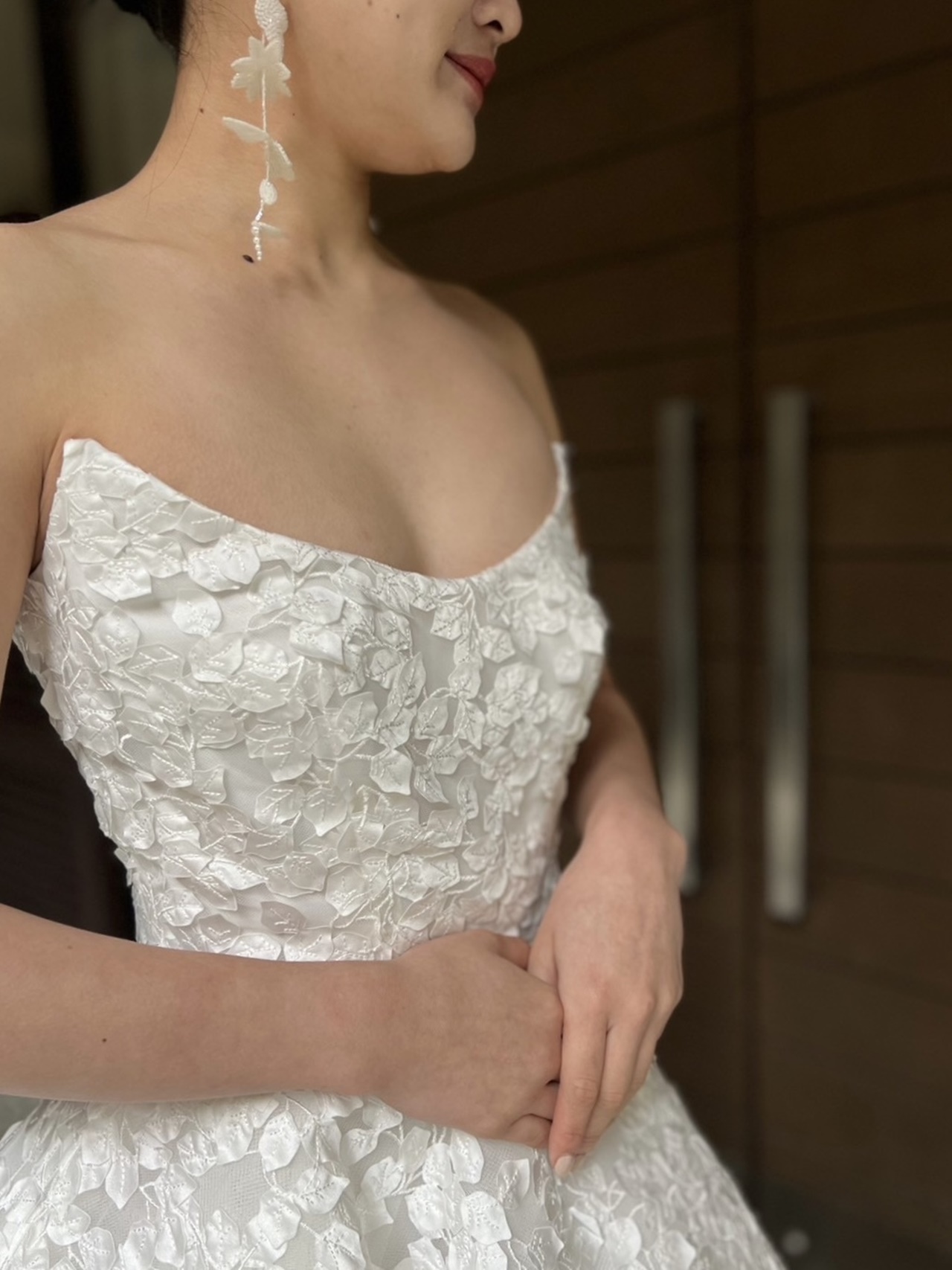 鮮やかで明るい純白のウェディングドレスには、同じくホワイトのビーズを用いたジェニファー ベアの大ぶりなイヤリングをあわせたモダンなコーディネートを