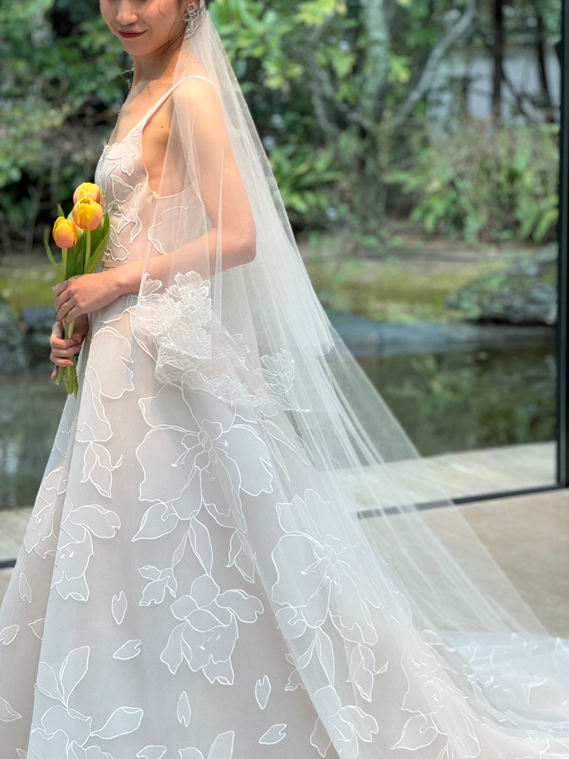 チューリップがあしらわれた柔らかいレースベールでフェミニンに仕上げてザガーデンオリエンタル大阪の緑豊かなチャペルにも映えるコーディネートを楽しんでいただけます