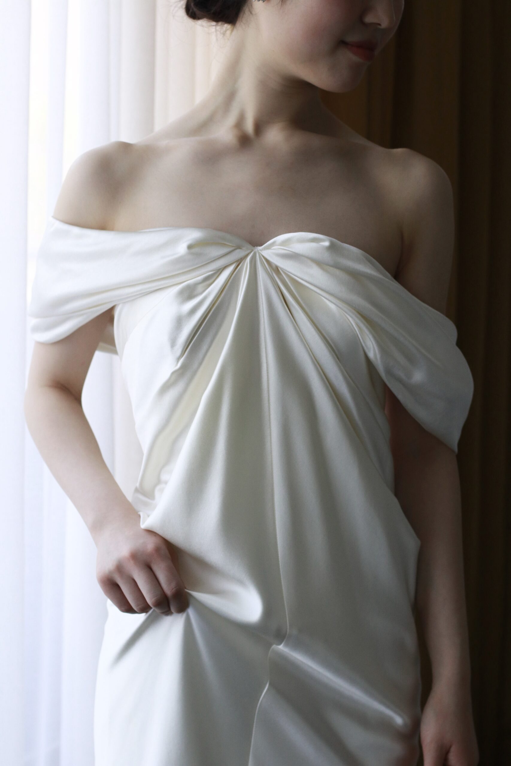 人気のドレスブランド、Daniellle Frankelの新作ウェディングドレスはお洒落なオフショルダーのデザインとスレンダーラインの流れが美しいウェディングドレスです