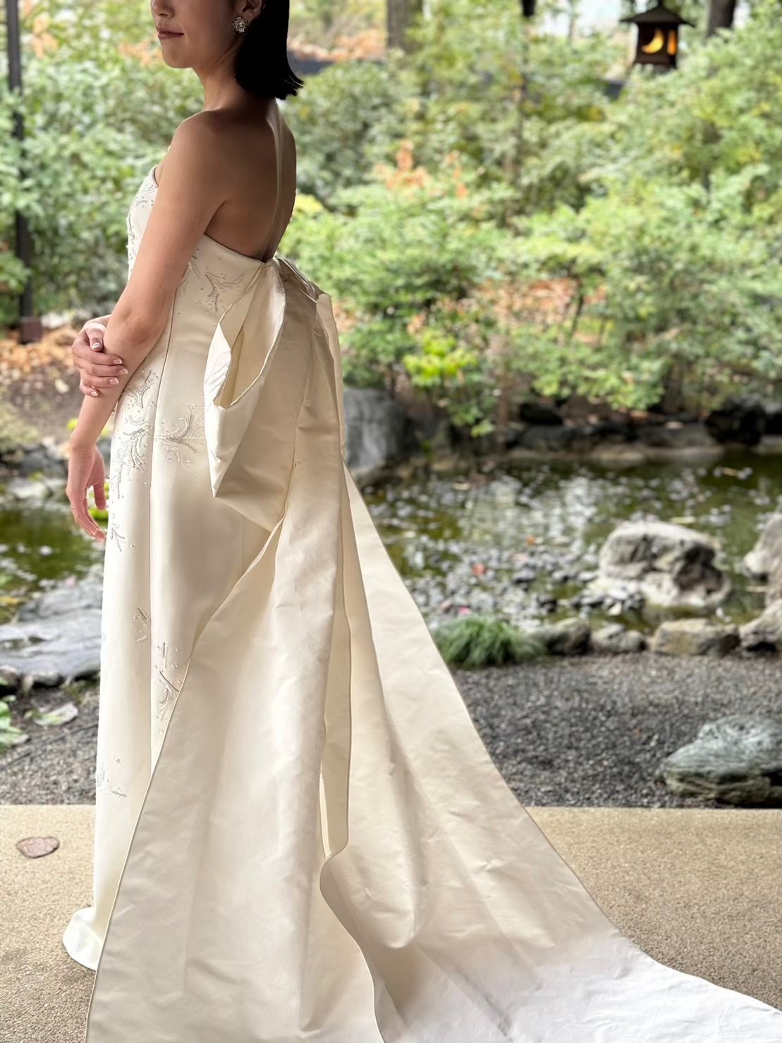 ザガーデンオリエンタル大阪の緑に映えるリボンが魅力のバックコンシャスなサフィヤのウェディングドレス