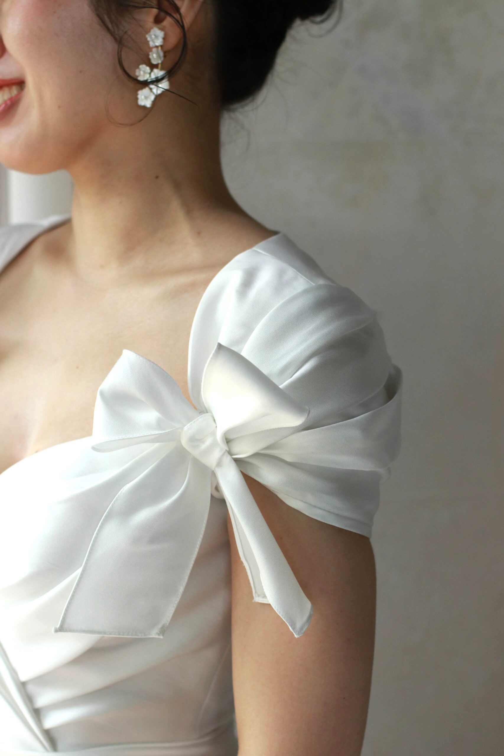 Reem Acraの新作ウェディングドレスは、上半身にあしらわれたリボンモチーフがフェミニンでロマンティックな印象です