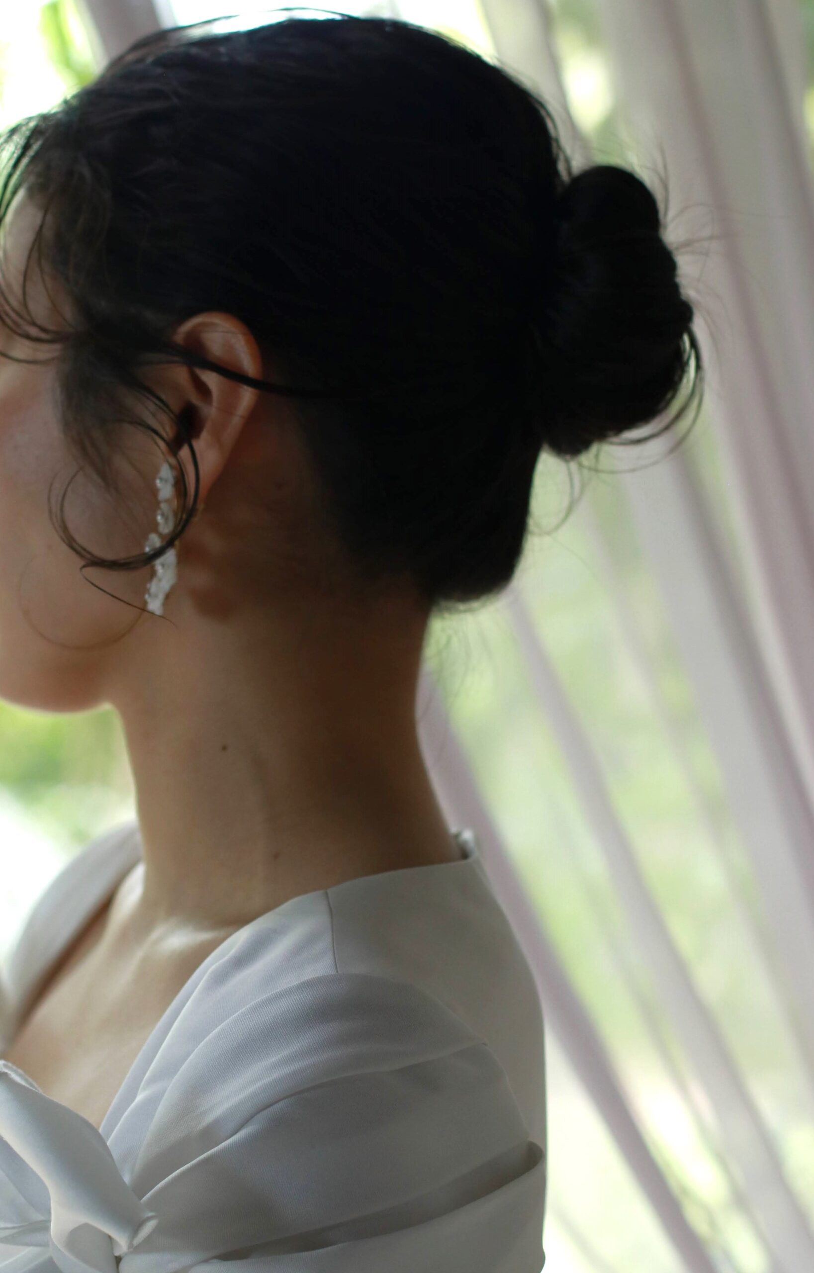 おくれ毛を活かしゆるくまとめたシニヨンのヘアスタイルは、上品かつフェミニンな結婚式のスタイルにぴったりでです