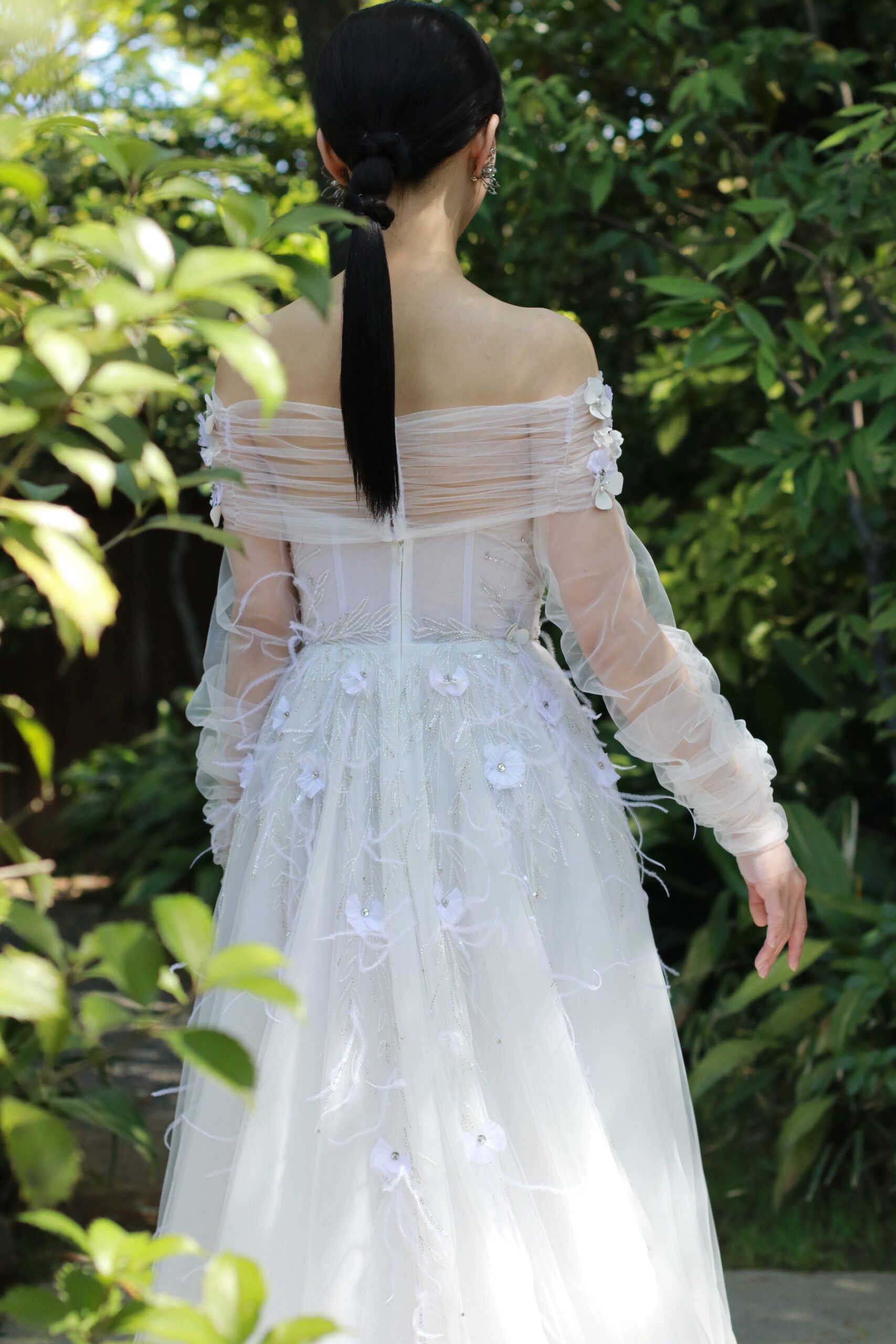 ガーデンオリエンタル大阪の自然に映えるおしゃれなフラワーやフェザーがついた細身Aラインのトリートのウェディングドレス