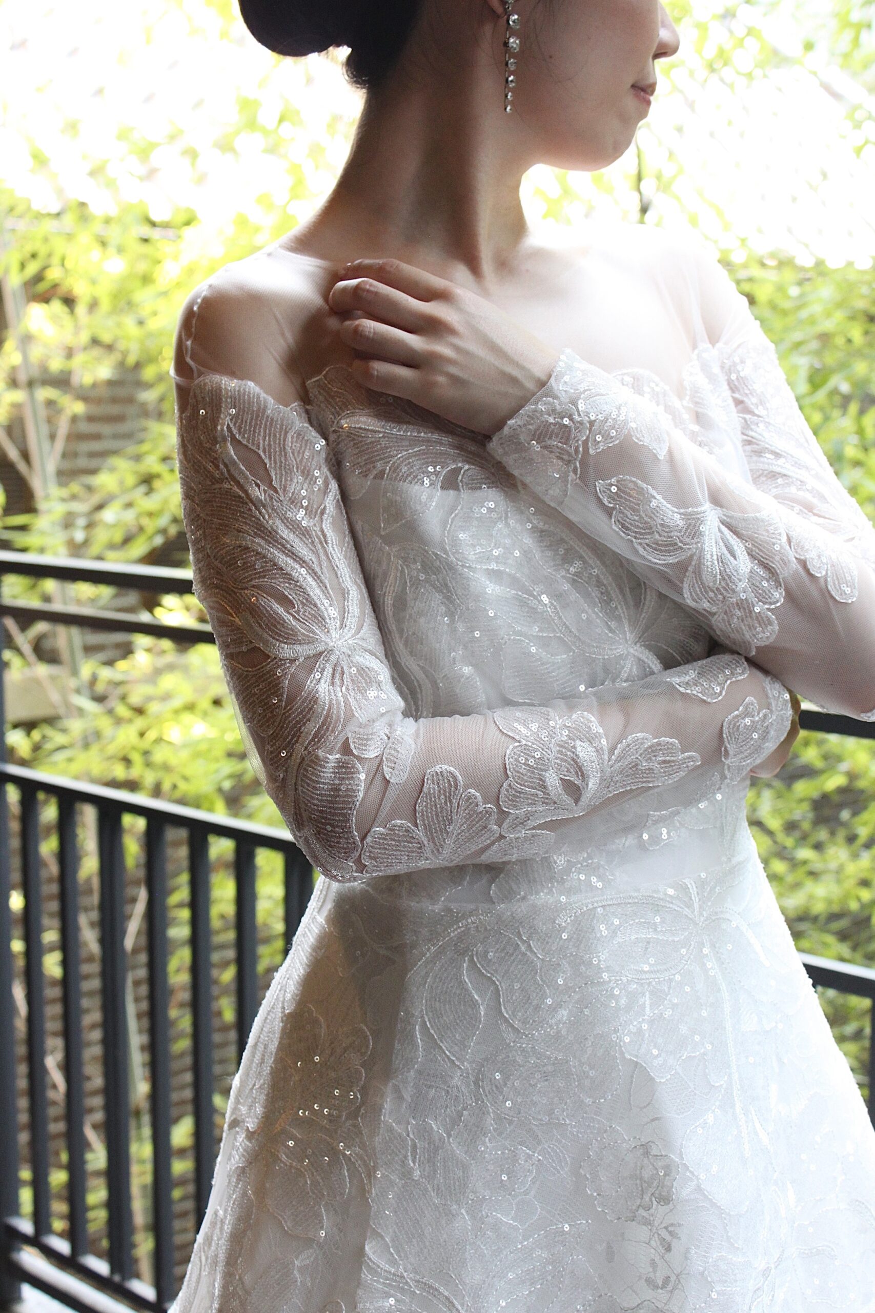 リームアクラのロングスリーブのウェディングドレスには、クラシカルでモダンな着こなしが叶うシルバービジューのイヤリングをあわせたコーディネートがおすすめです