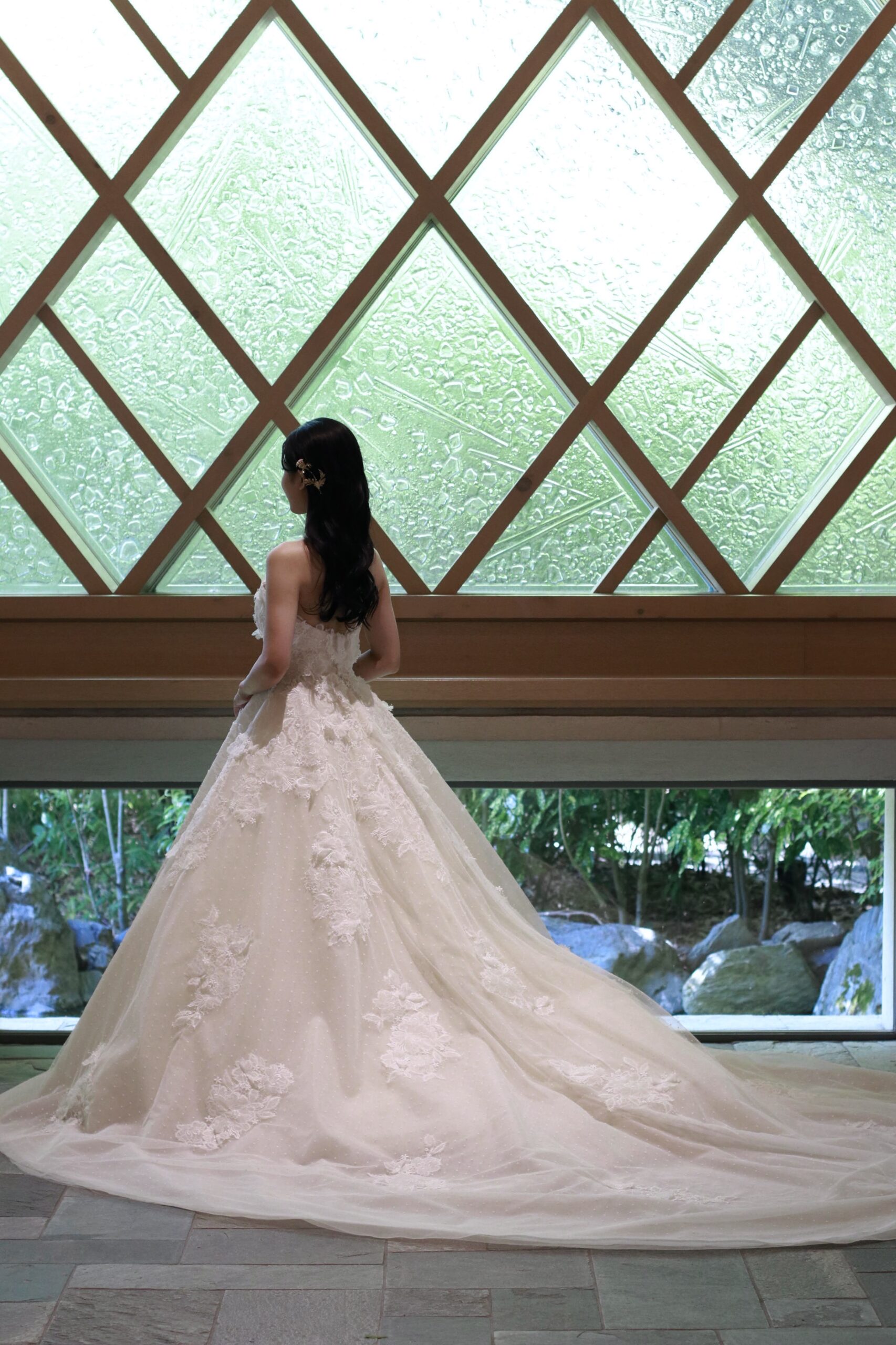 ガーデンオリエンタル大阪のチャペルに映えるトリート大阪店でお取り扱いをしているプリンセスラインでレースがふんだんに施された透明感溢れるウェディングドレス