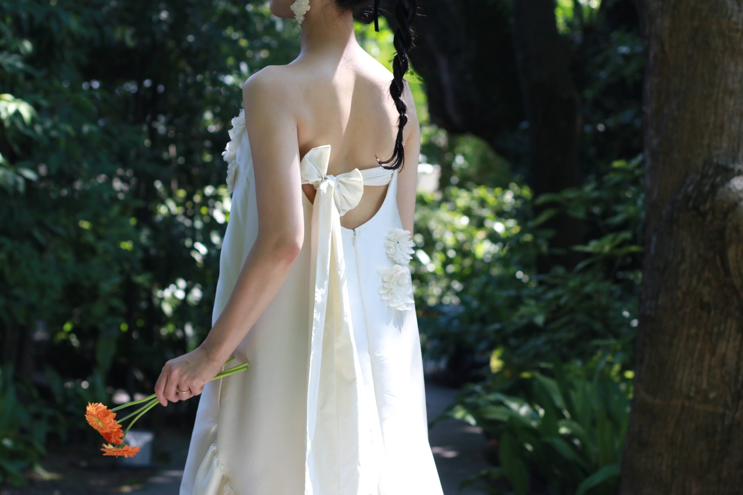 大阪の自然でナチュラルな会場におすすめの遊び心を感じるファッショナブルなデザインと上質さを兼ね備えた背中のリボンが可愛いお洒落なウェディングドレス