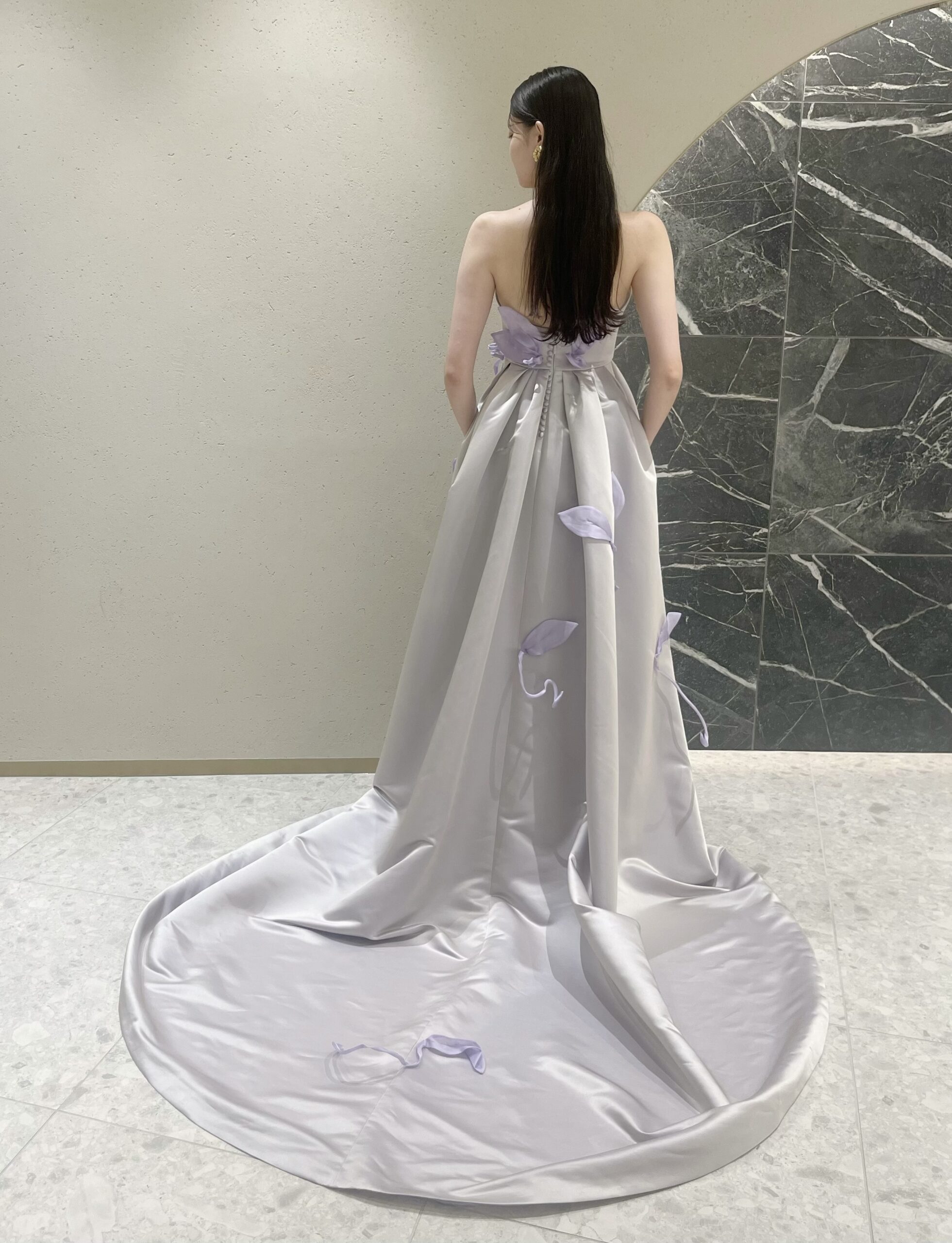 バックスタイルのトレーンが長く結婚式らしさと存在感のあるラベンダーのカラードレスは後ろ姿も美しいです