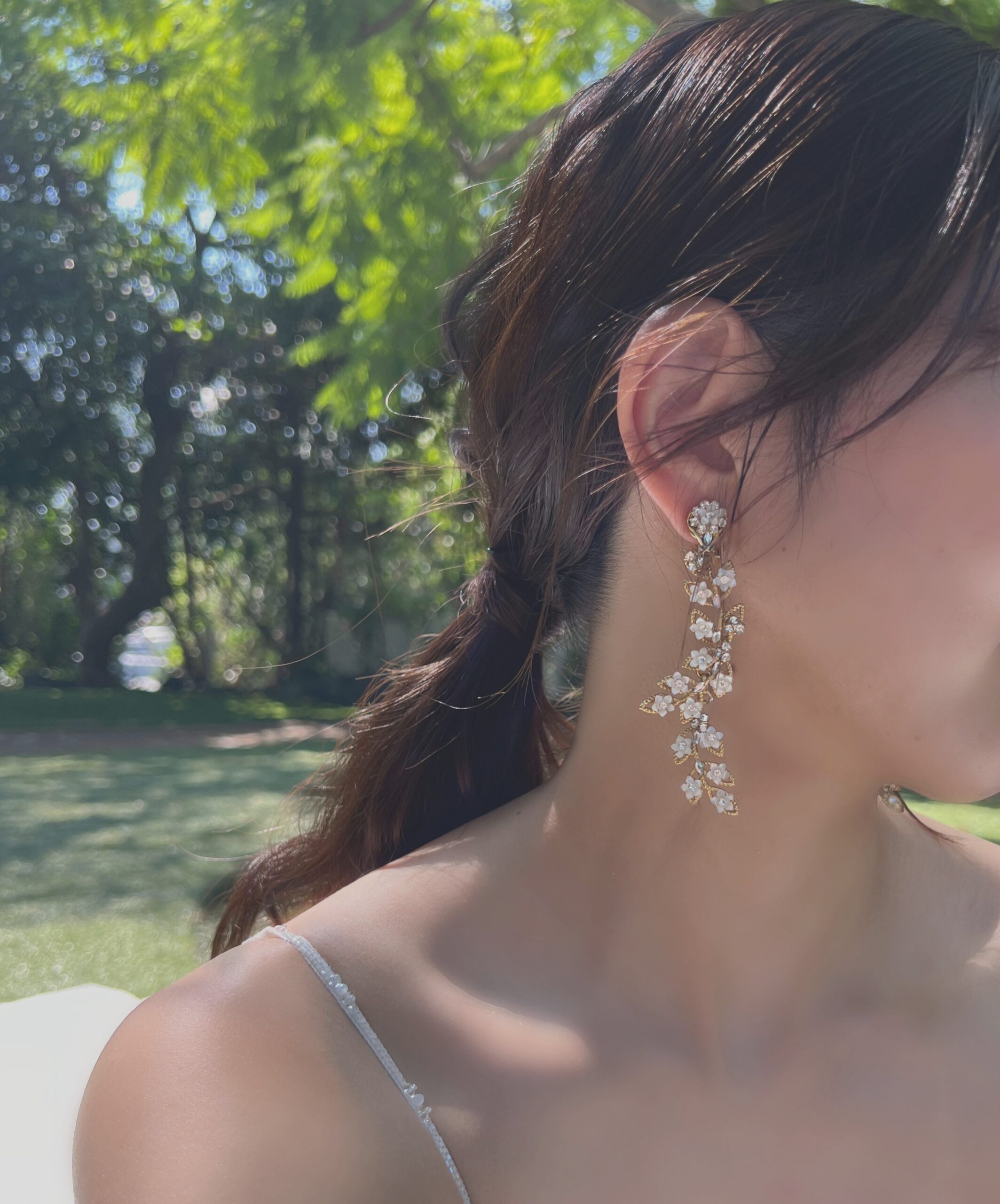 リラックスしてお過ごしいただくため、ヘアスタイルはローポニーテールに。耳元はドレスと一緒に揺れるようなフラワーとリーフモチーフのイヤリングで仕上げました。
