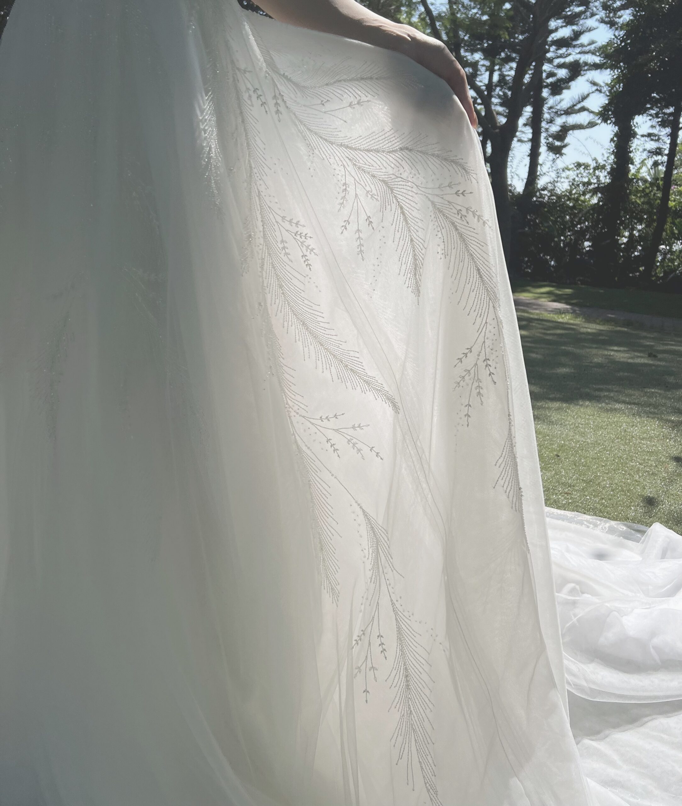 柔らかくしなやかな風からインスパイアされたこちらのウェディングドレスは、植物の葉と羽根のビーディングを柔らかな生地と組み合わせることで、そよ風の吹く様子を表現しています。