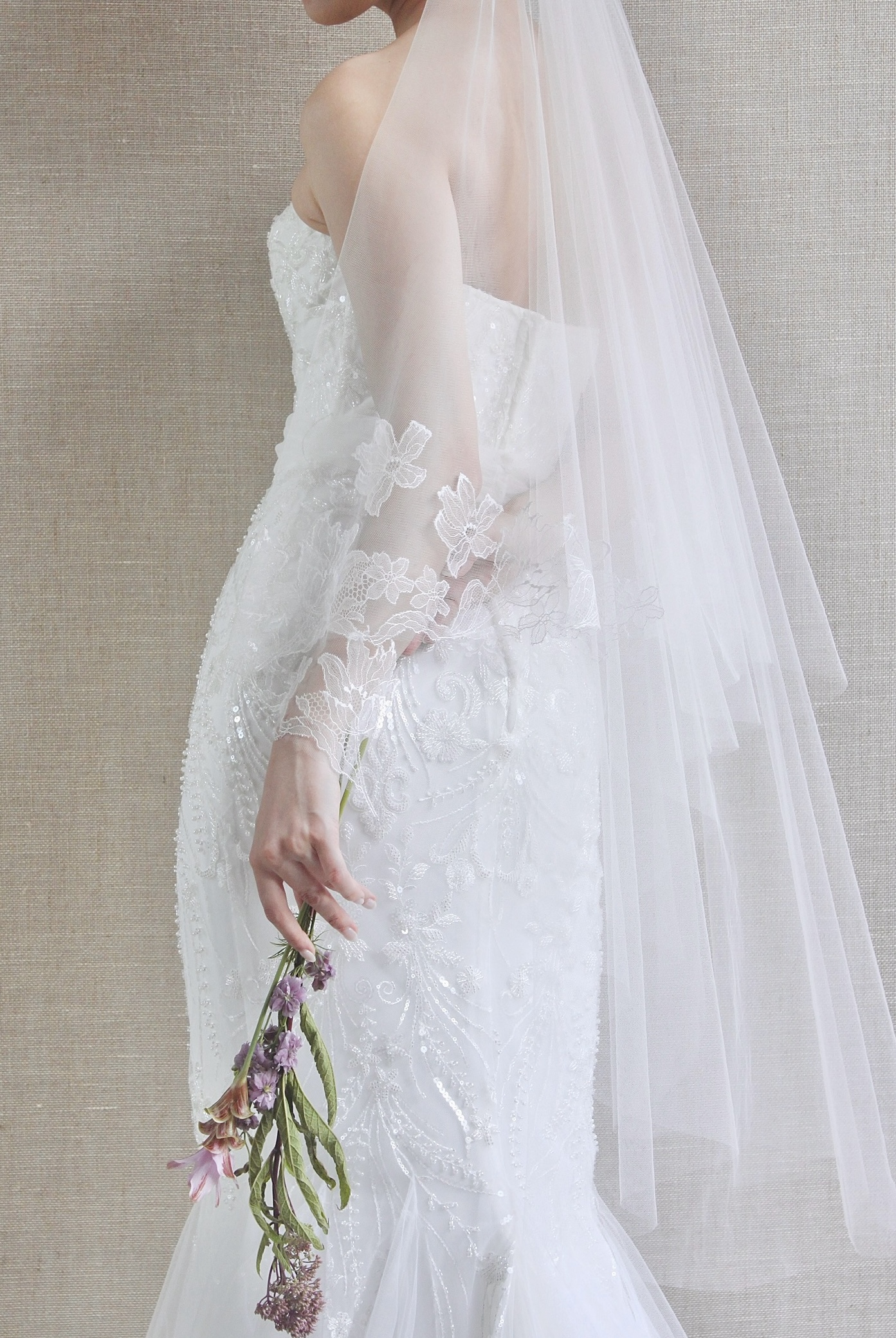 チューリップの華麗なレースがあしらわれたシルクチュールのベールを合わせた花嫁の透明感と儚げさを演出するコーディネート