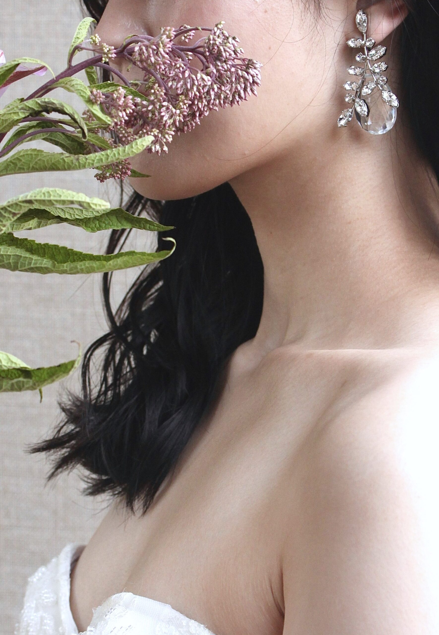 ダウンスタイルでリラックス感を与え、大ぶりのクリスタルの輝きが美しいイヤリングを合わせるエフォートレスなコーディネート