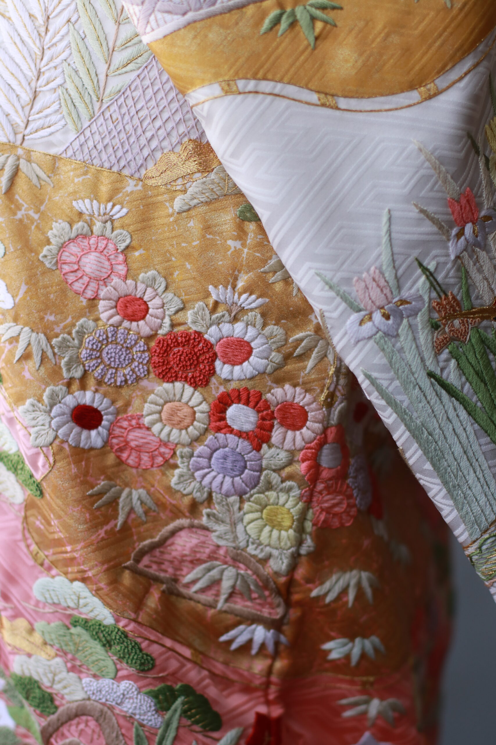 地の白から橙色への濃淡が印象的であり、熟練の職人により一針ずつ紡がれた繊細な模様をすべて手刺繍で縫い上げた一着をザトリートドレッシングアディションよりご紹介いたします。