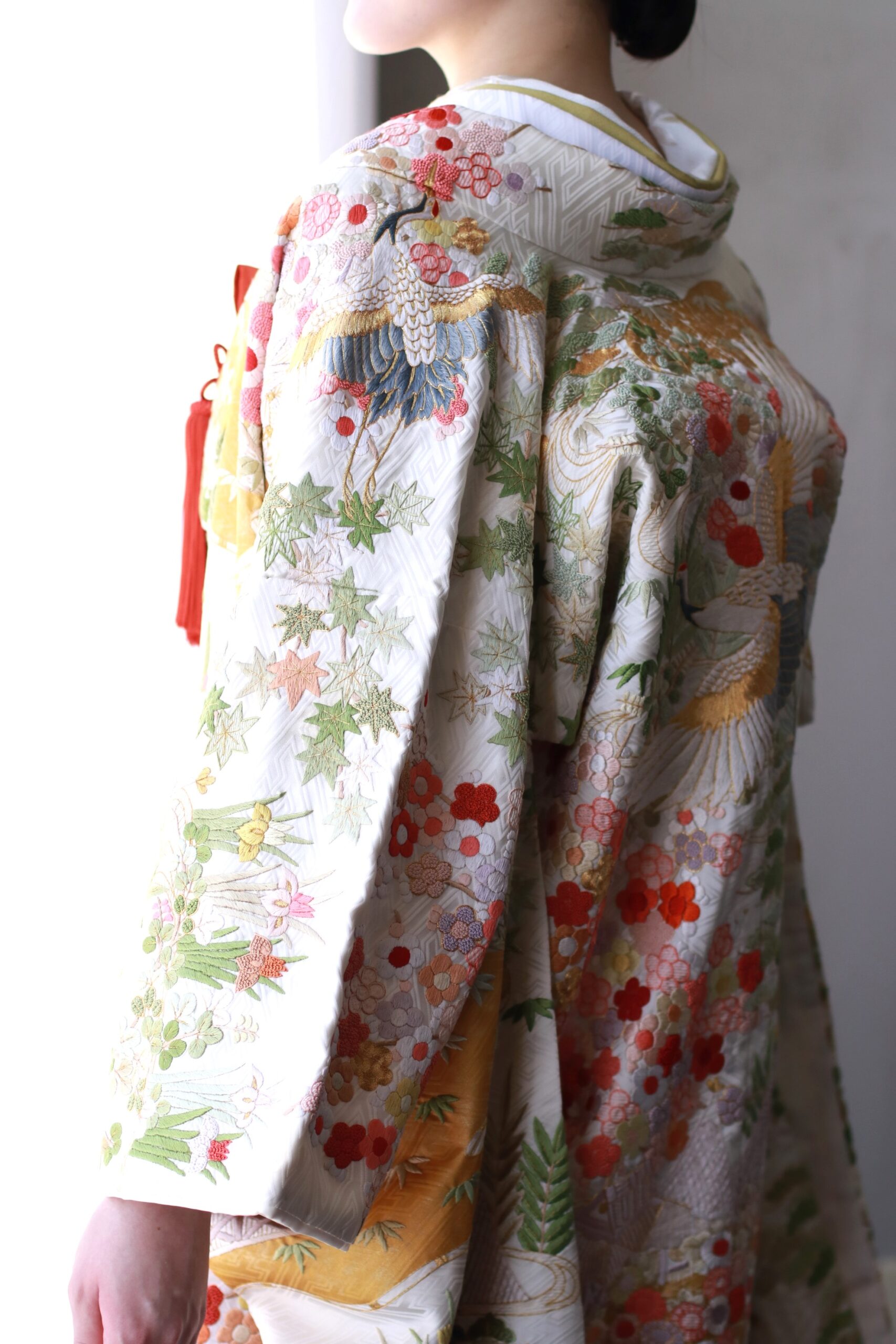 地の白からオレンジのグラデーションが美しい緑や赤、ピンクなど色鮮やかな刺繍が華やかな色打掛のご紹介