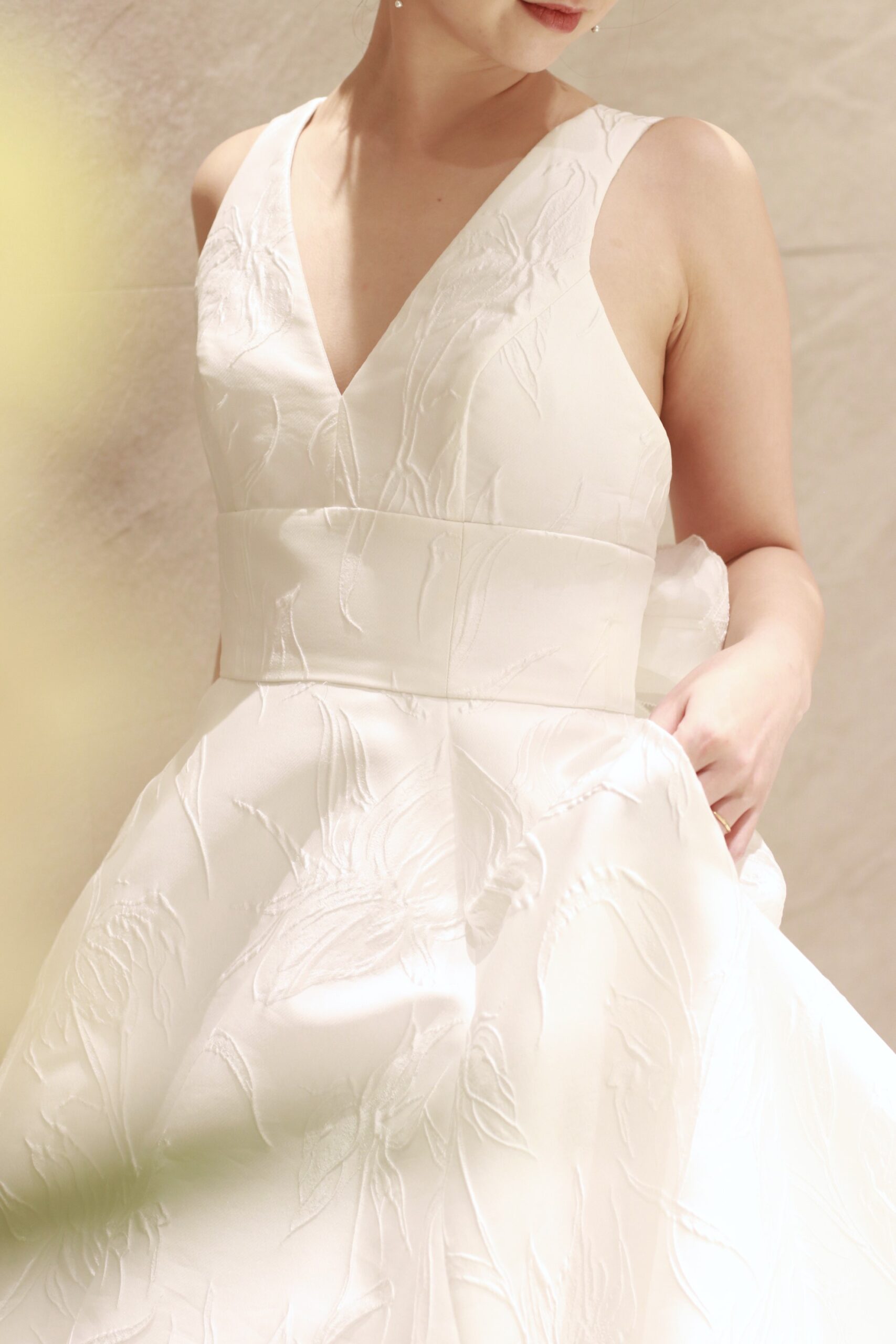 東京のアディション店に届いたアムサーラの新作のウェディングドレスは、女性らしいシルエットを引き立てるAラインのシルエットに百合が浮かび上がるジャガードの生地を贅沢に使用した上質な一着です。