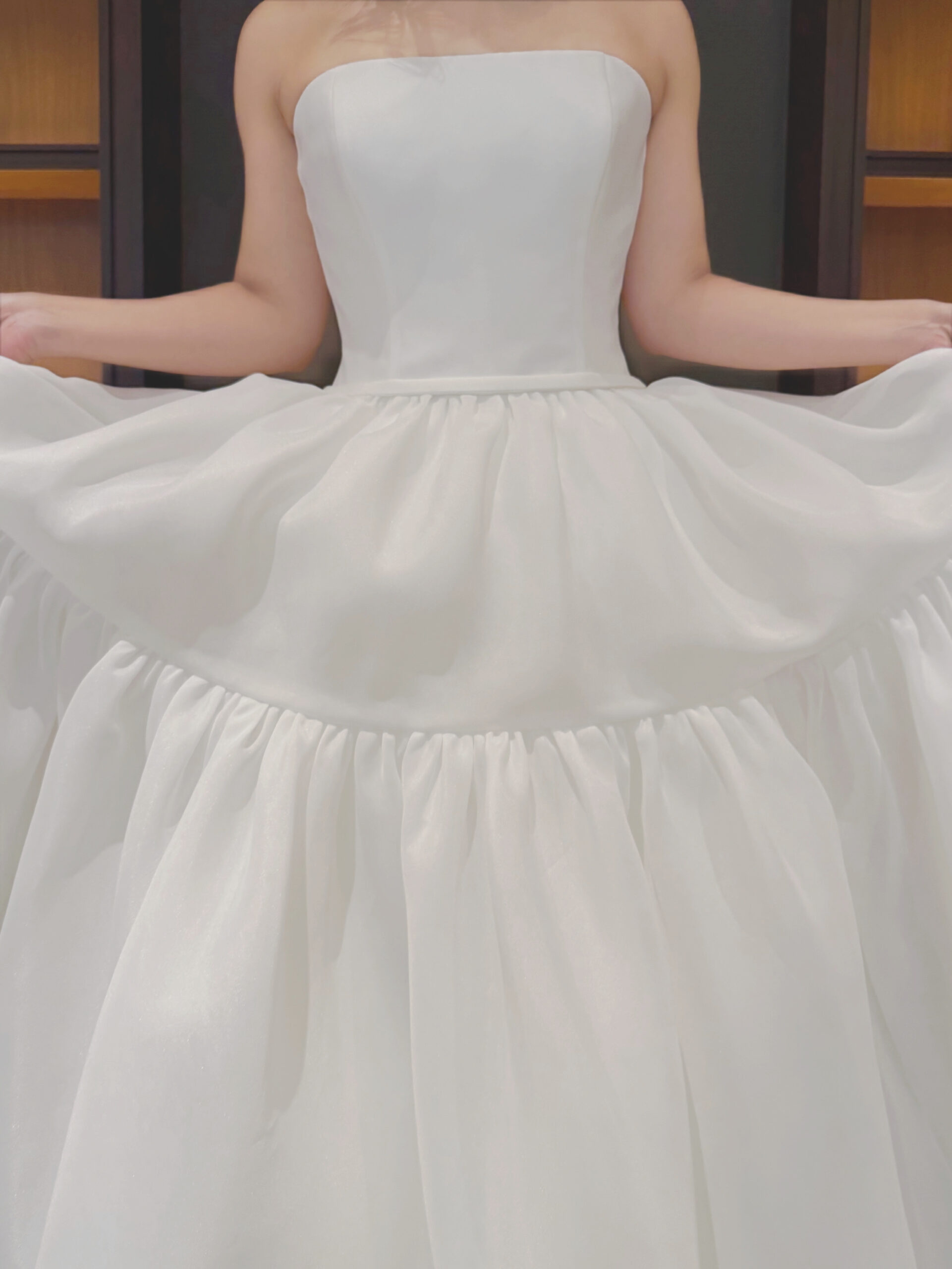 半身のすっきりとシンプルなデザインとは対照的にふんわりと広がる2段のティアードスカートは動きのあるような華やかなシルエットを創り出す新作ウェディングドレス。