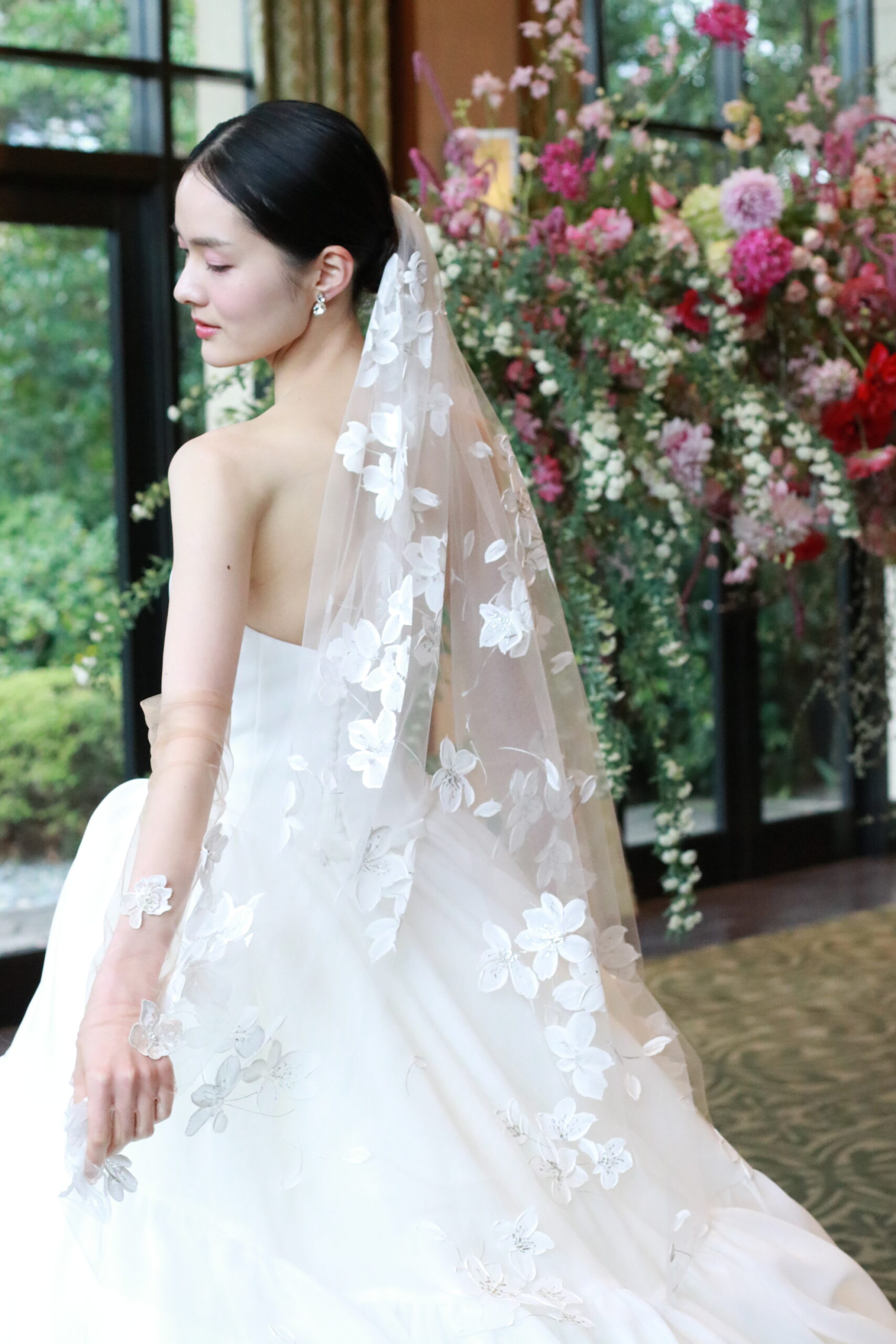 プリンセスラインのウェディングドレスに合わせた、アムサーラがデザインしたウェディングベールはハンドペイントで花びらデザインされています。