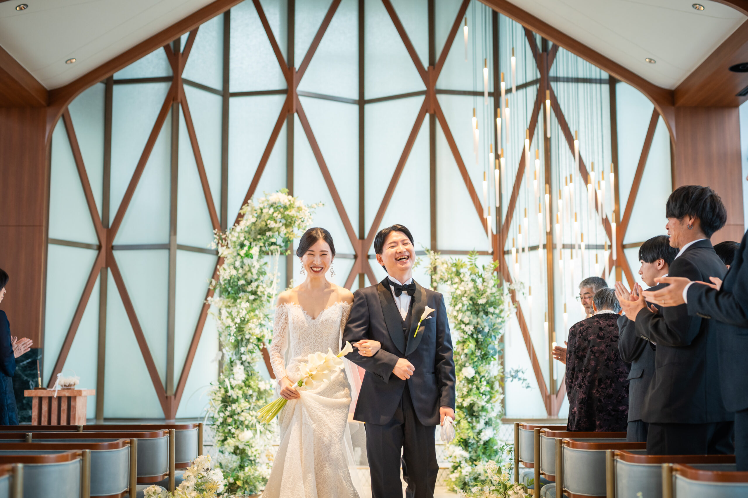 洗練されたモダンな空間の中にどこかあたたかみを感じるザマークグランドホテルのチャペルで、笑顔あふれるお写真を残される新郎新婦様