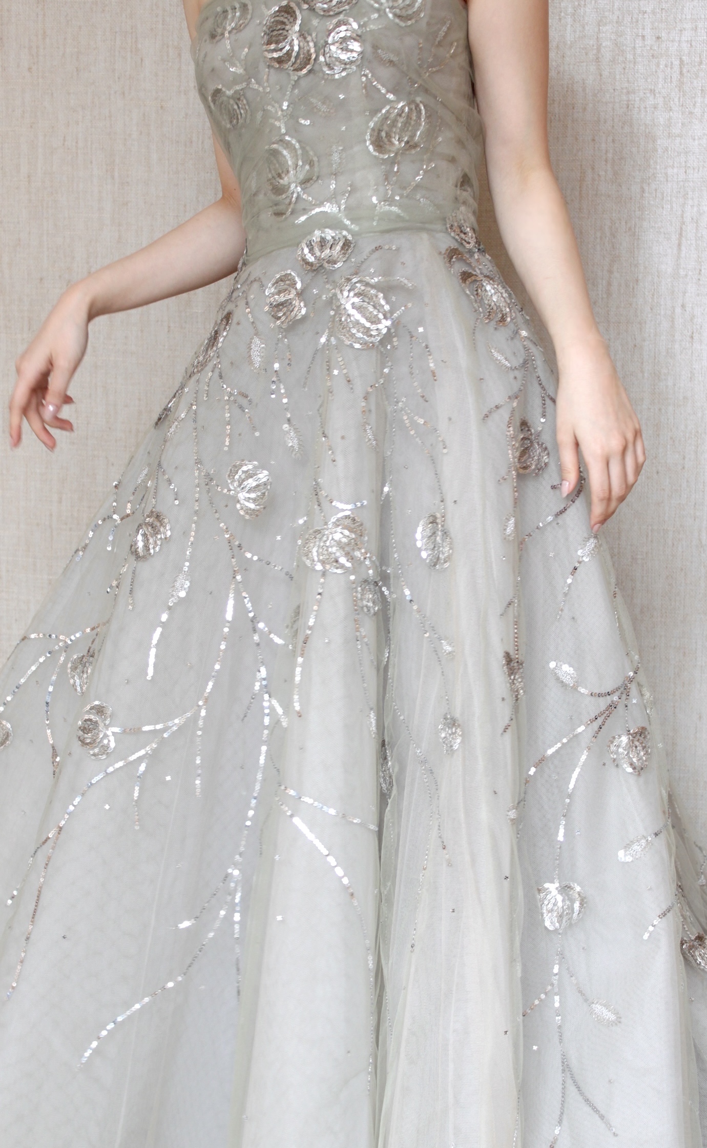 くすみグリーンを引き立てるシルバーのスパンコールは胸元から膝にかけて流れるようにデザインされ花嫁の優美さを演出してくれます。