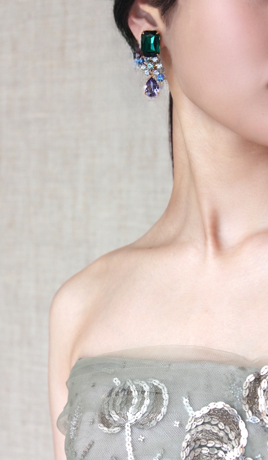 耳元にはリーム アクラのゴージャスでラグジュアリーなドレスに合わせて鮮やかなカラーリングが目を惹くキャッチーなイヤリングをセレクト
