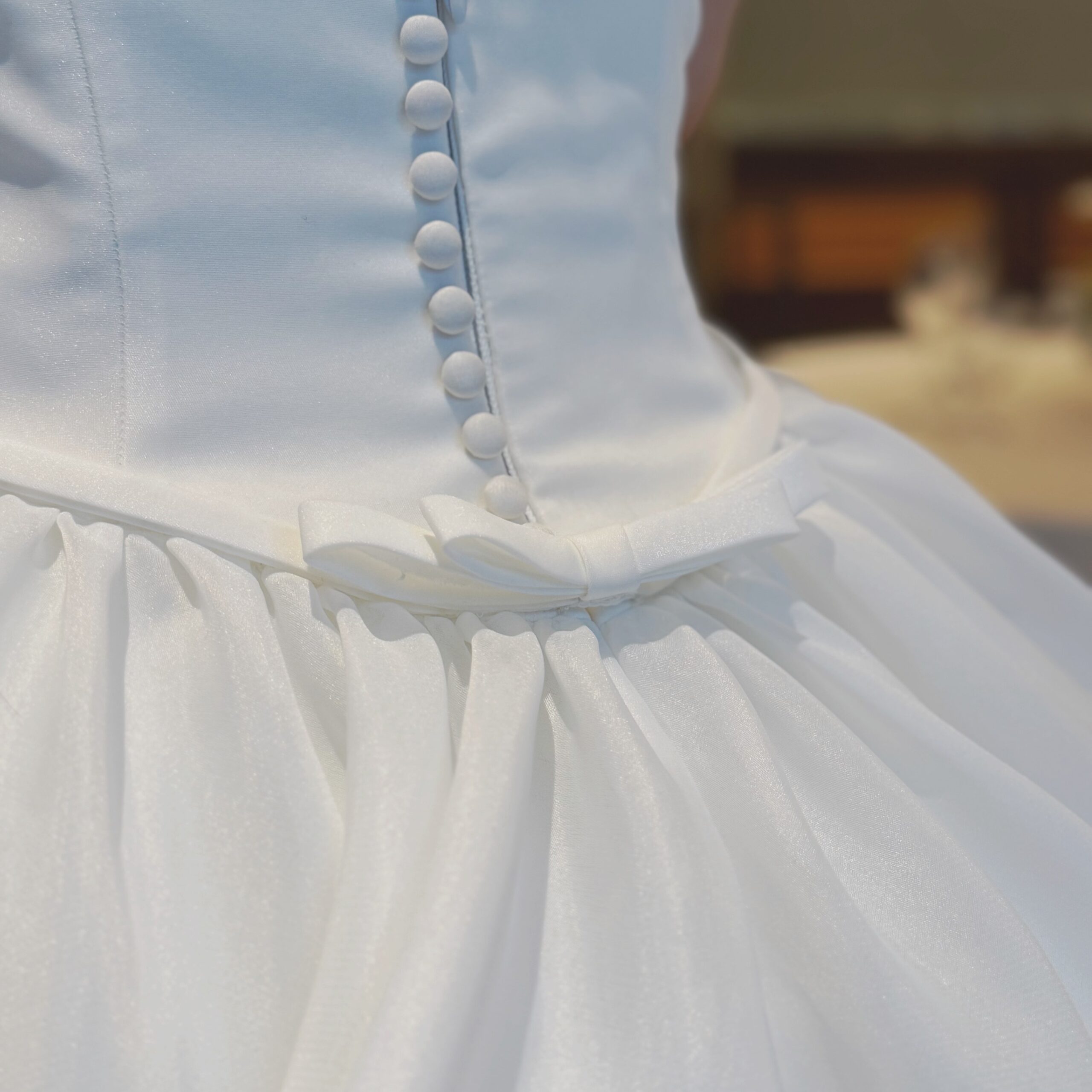 THE TREAT DRESSING FUKUOKAの新作ウェディングドレスは、バックスタイルにくるみボタンとリボンをあしらい女性らしい可憐な印象に。