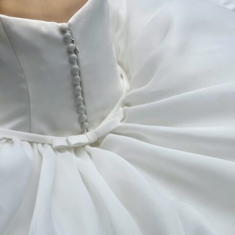 ガザール生地をふんだんに使用し、高級感と構造的な美しさを表現したプリンセスラインのウェディングドレス