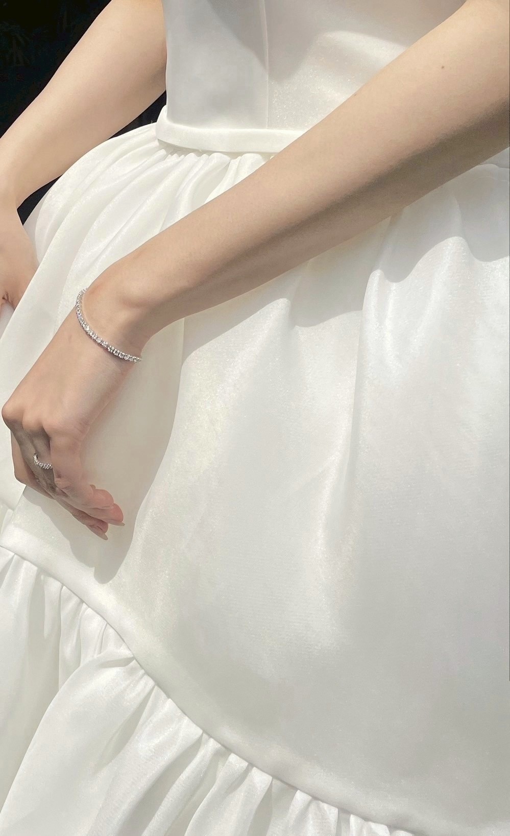 テニスジュエリーのさりげなく煌めくダイヤモンドが、花嫁の仕草ひとつひとつを美しく引き立ててくれるコーディネートに仕上げます