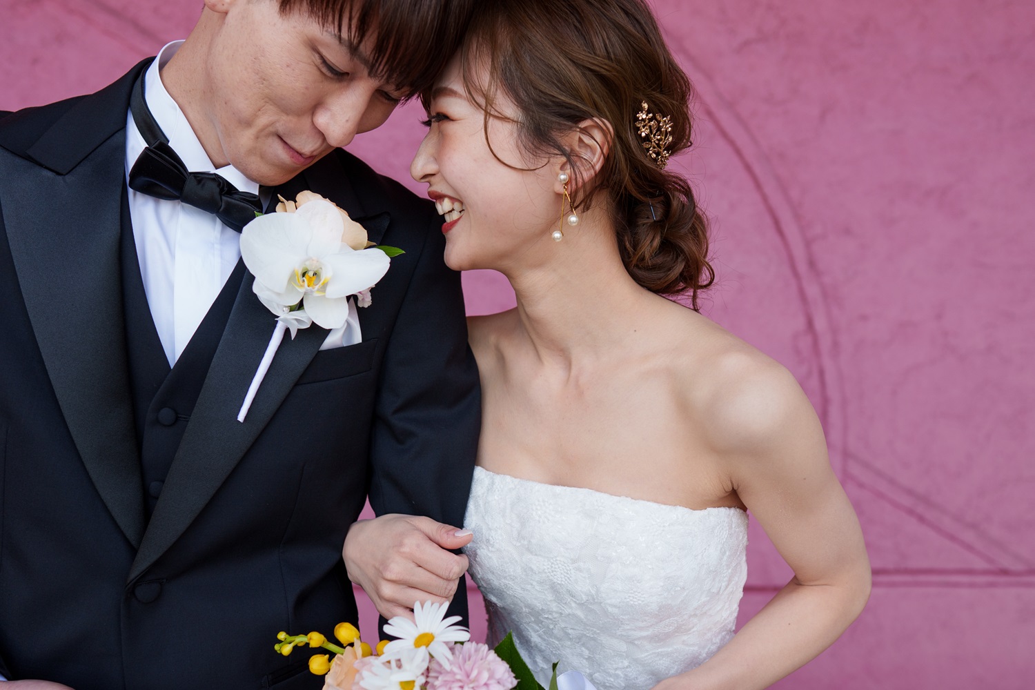 福岡市内の結婚式場であるザ ルイガンズ スパ&リゾートで叶える結婚式では、前撮りでも人気のビビッドピンクの壁を前にしたおしゃれな写真が映えます