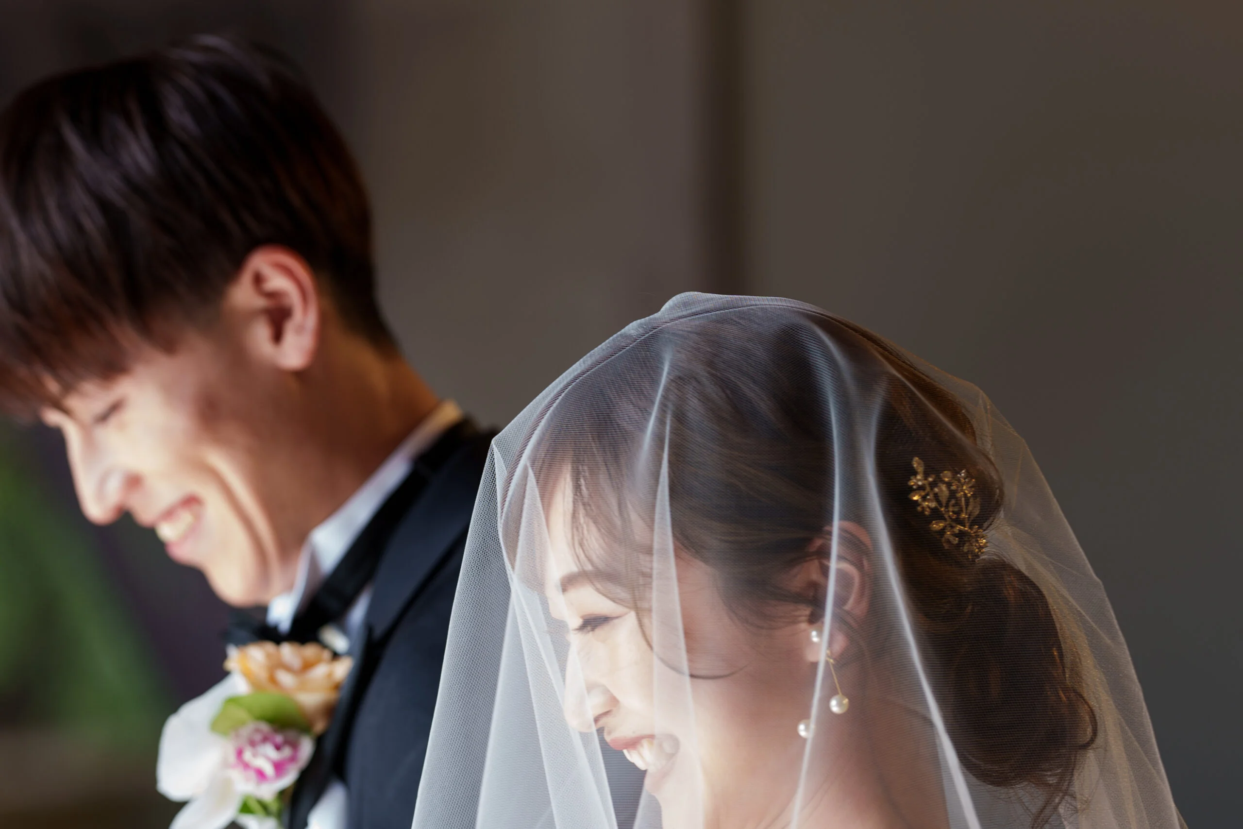 透明感のある無地ベールには、華やかなパールのイヤリングとゴールドのバックカチューシャを合わせた、上品なスタイリングを